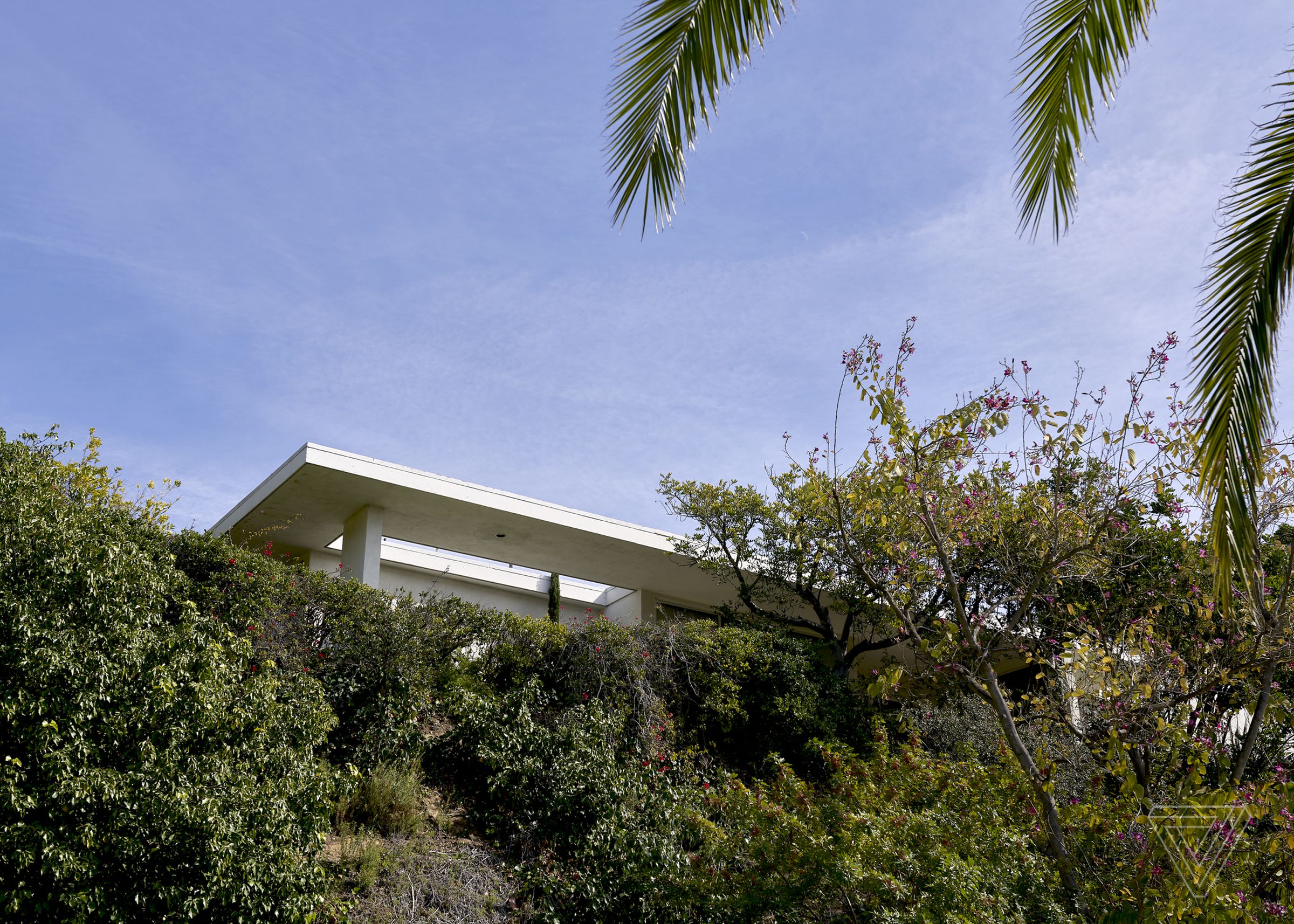 The house sits in the hills of Los Angeles with a view of the city.
