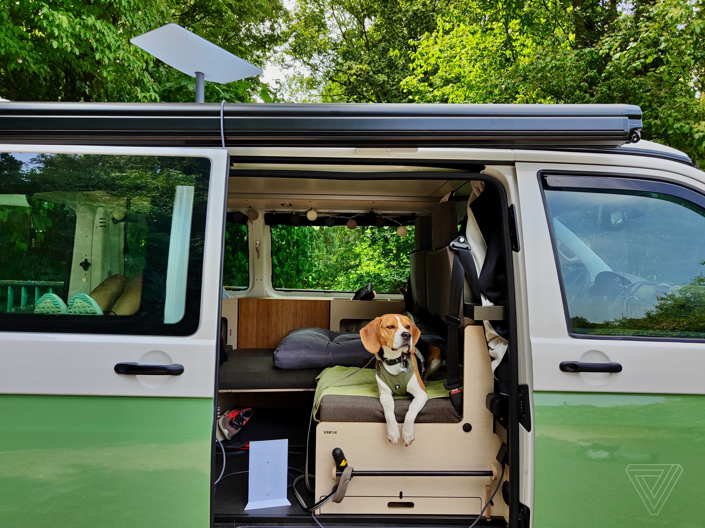 Hank sitting next to the Wi-Fi router as the Starlink RV dish connects through the trees.