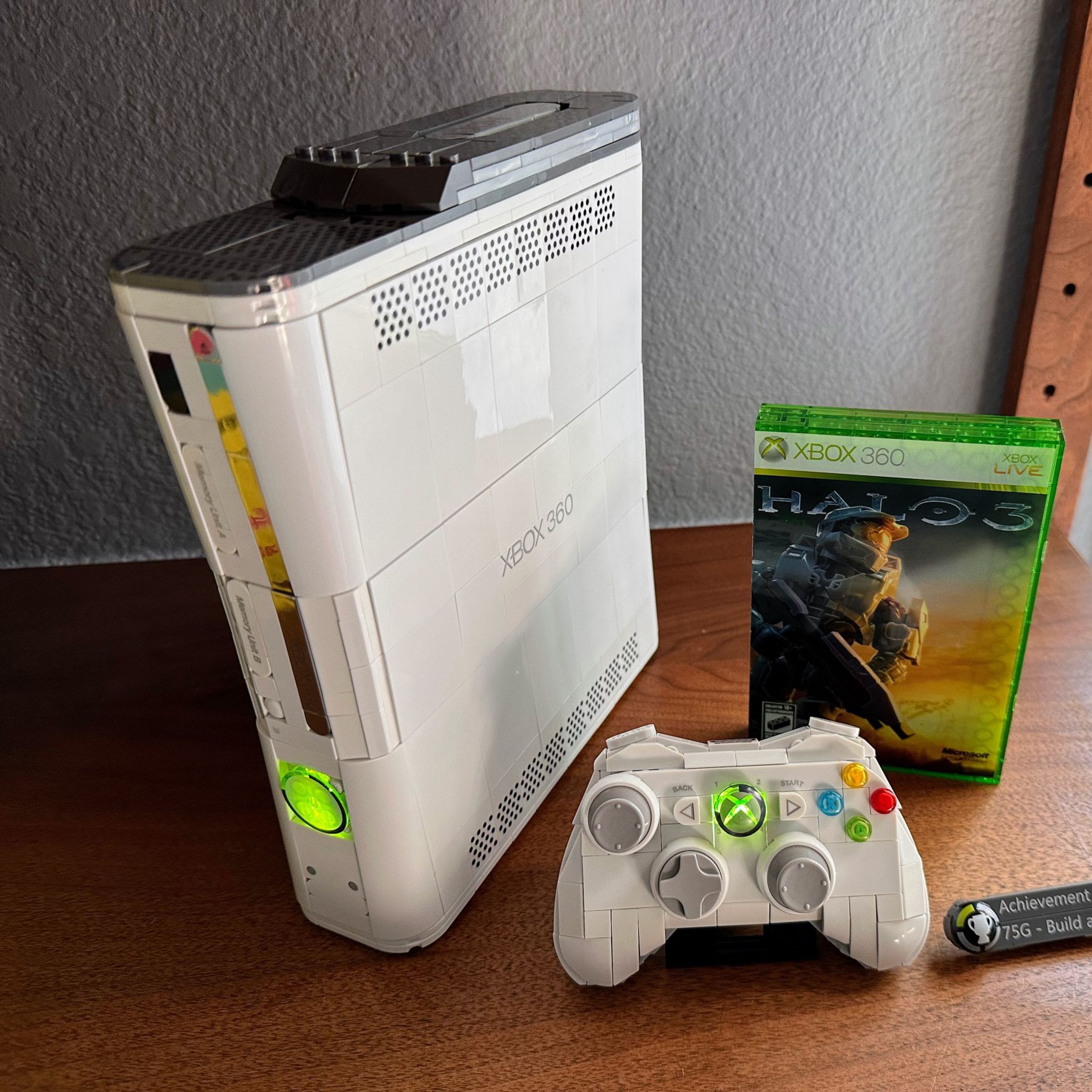 A white Xbox 360 with a hard drive, controller, and a “copy” of Halo 3 — you build them all with bricks.