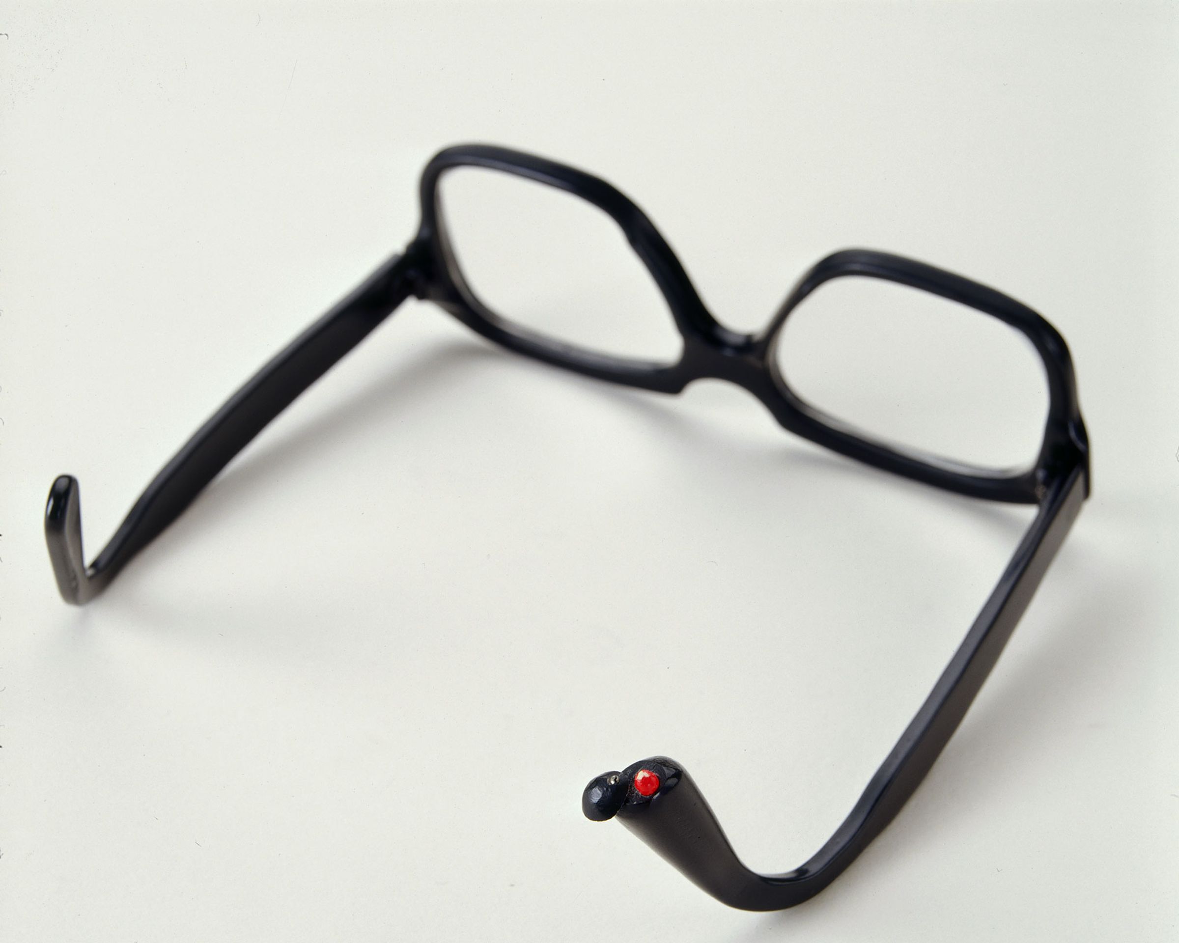 Upside-down pair of glasses where you can see a pill hidden in the arm.