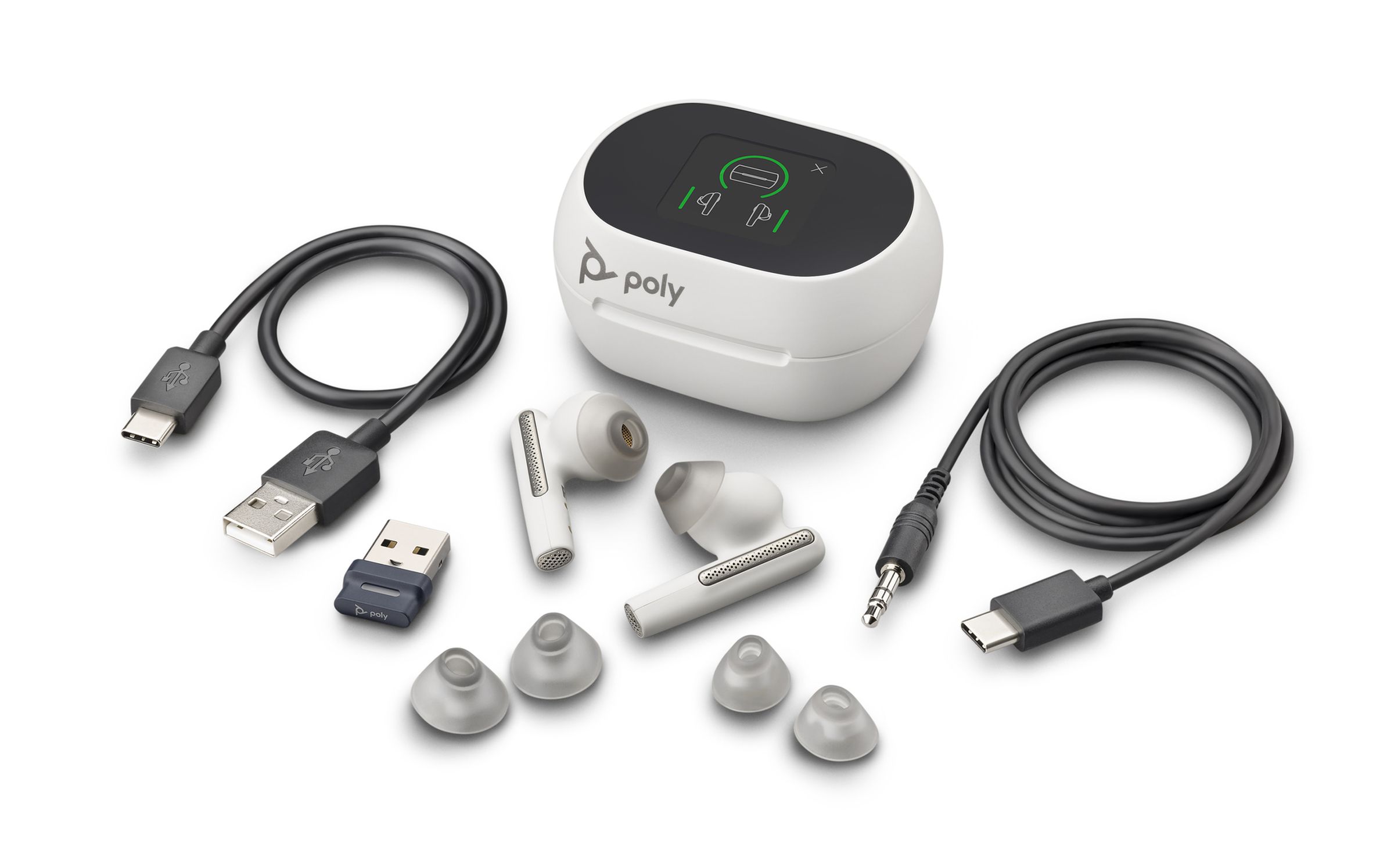 Picture of the Poly Voyager Free 60 Plus showing its USB A to USB C charging cable, USB A bluetooth dongle, three sets of silicone tips, the earbuds, the charging case with screen, and a USB C to 3.5mm headphone jack cable.