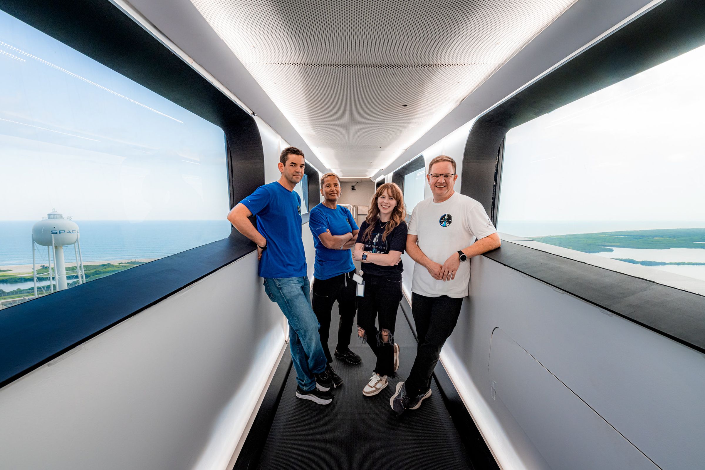From left to right, Jared Isaacman, Sian Proctor, Hayley Arceneaux, and Christopher Sembroski pose for a photo inside SpaceX’s Crew Access Arm, the bridge passengers use to board Crew Dragon on the launchpad.