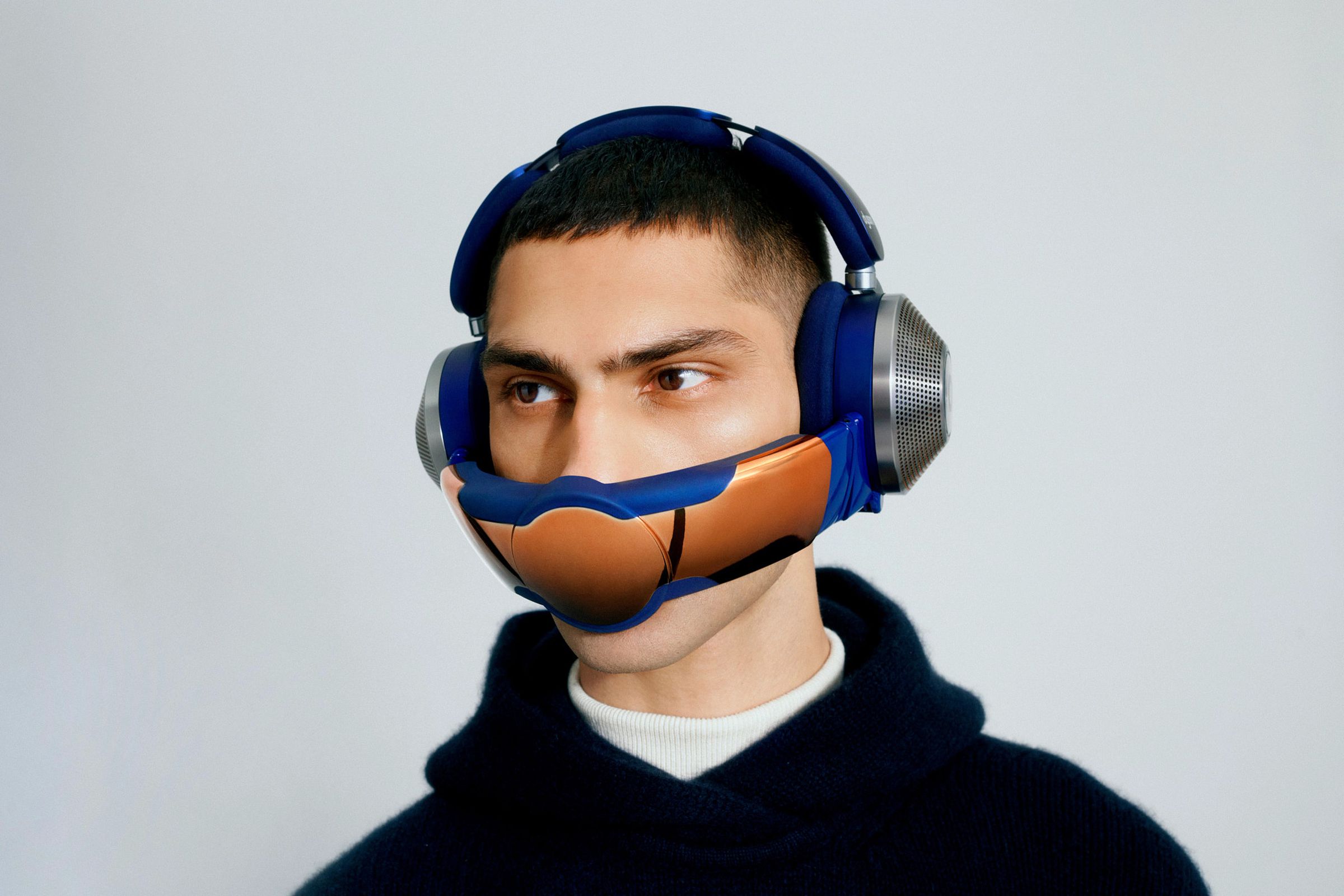 A person against a blank gray background. They are wearing the Dyson Zone with the air-purifying visor concealing their mouth.