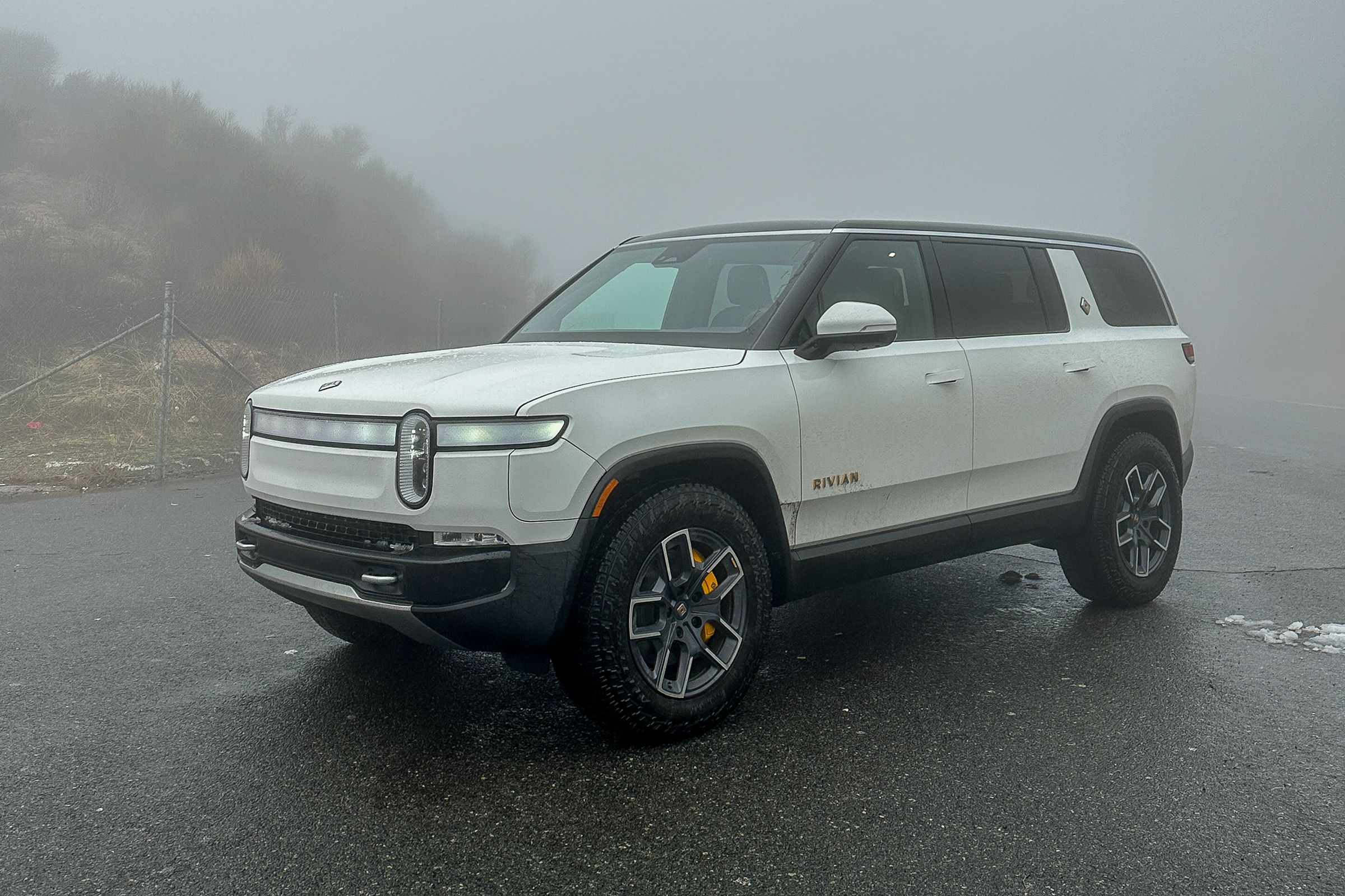 White R1S SUV in a foggy environment