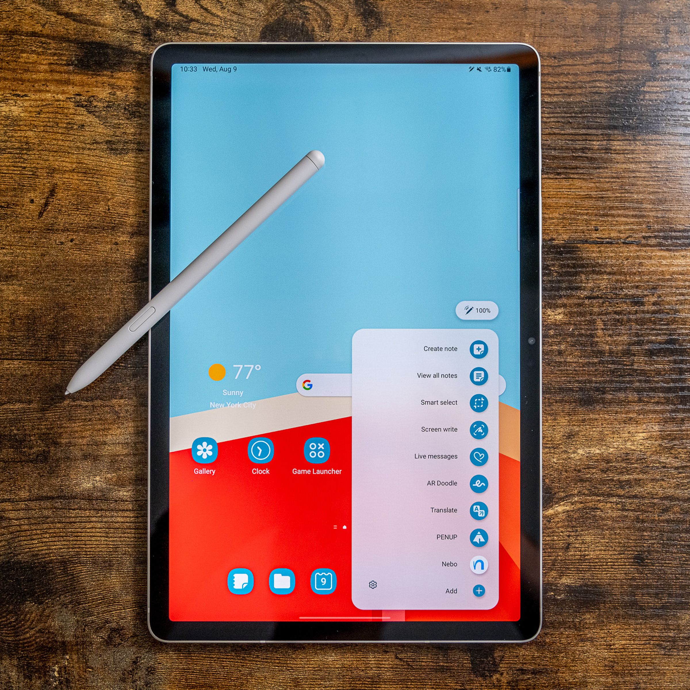 The Samsung Galaxy Tab S9 tablet resting on a wood table with its stylus.