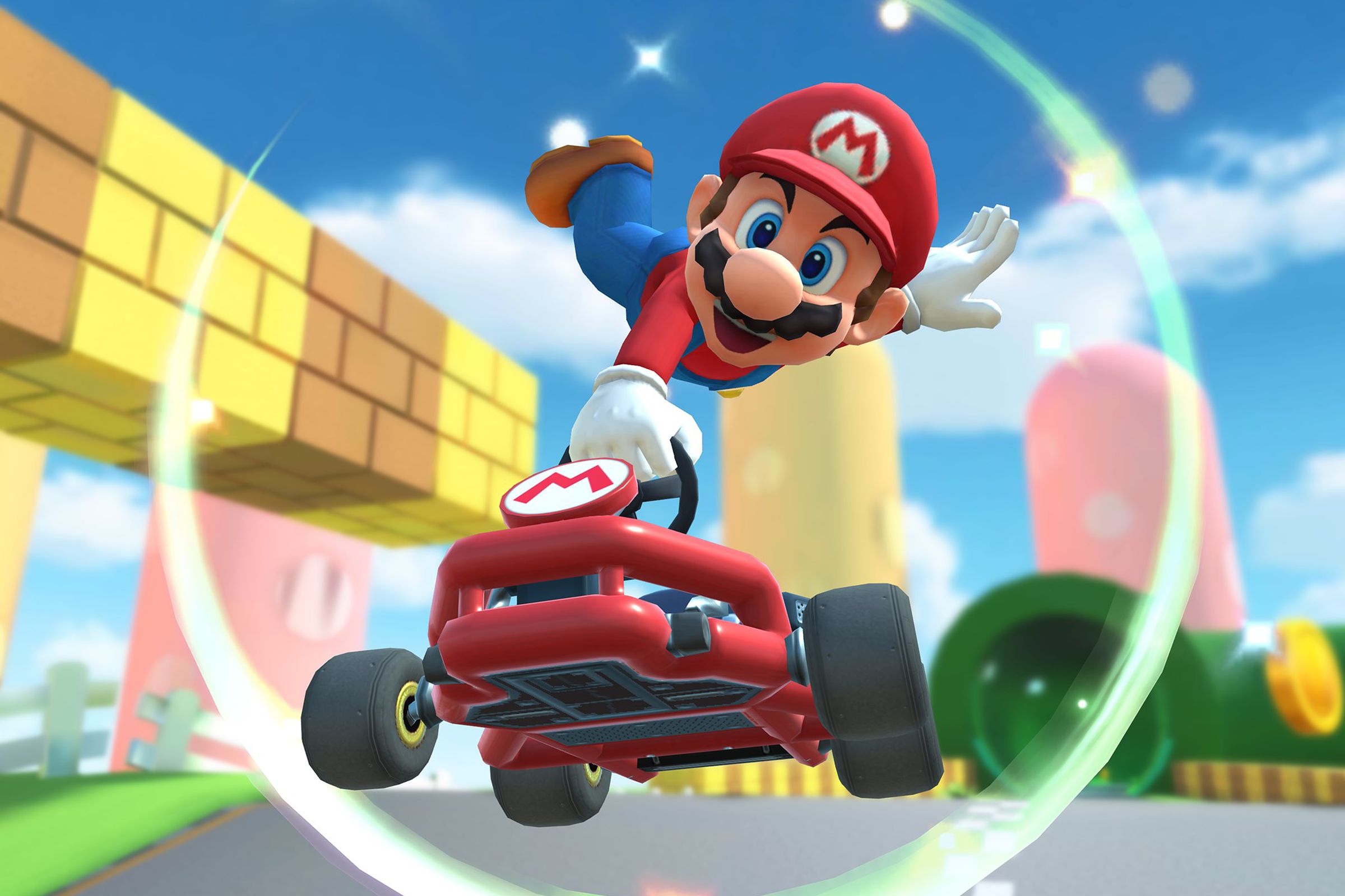 Mario in a car while racing in the game Mario Kart Tour.