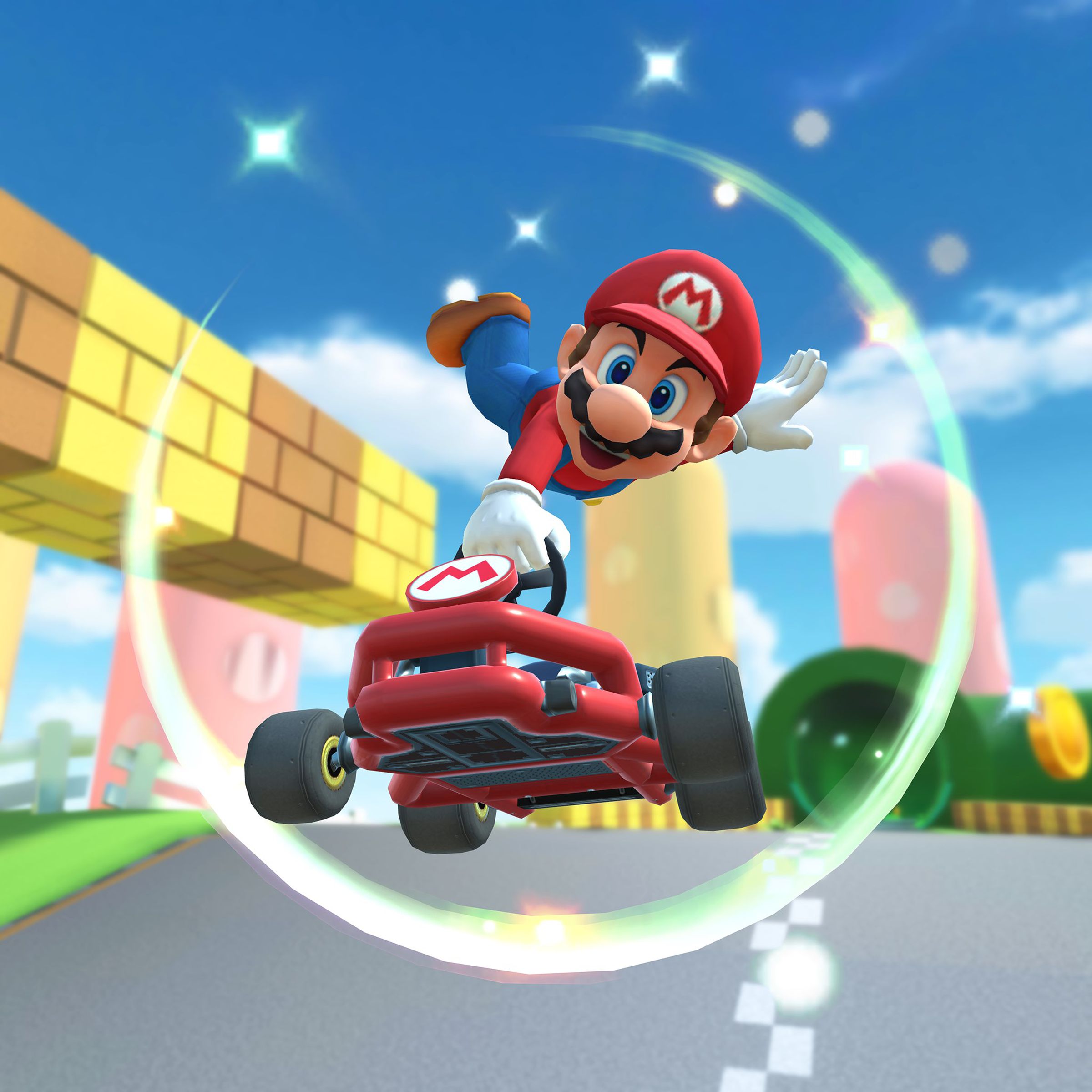 Mario in a car while racing in the game Mario Kart Tour.