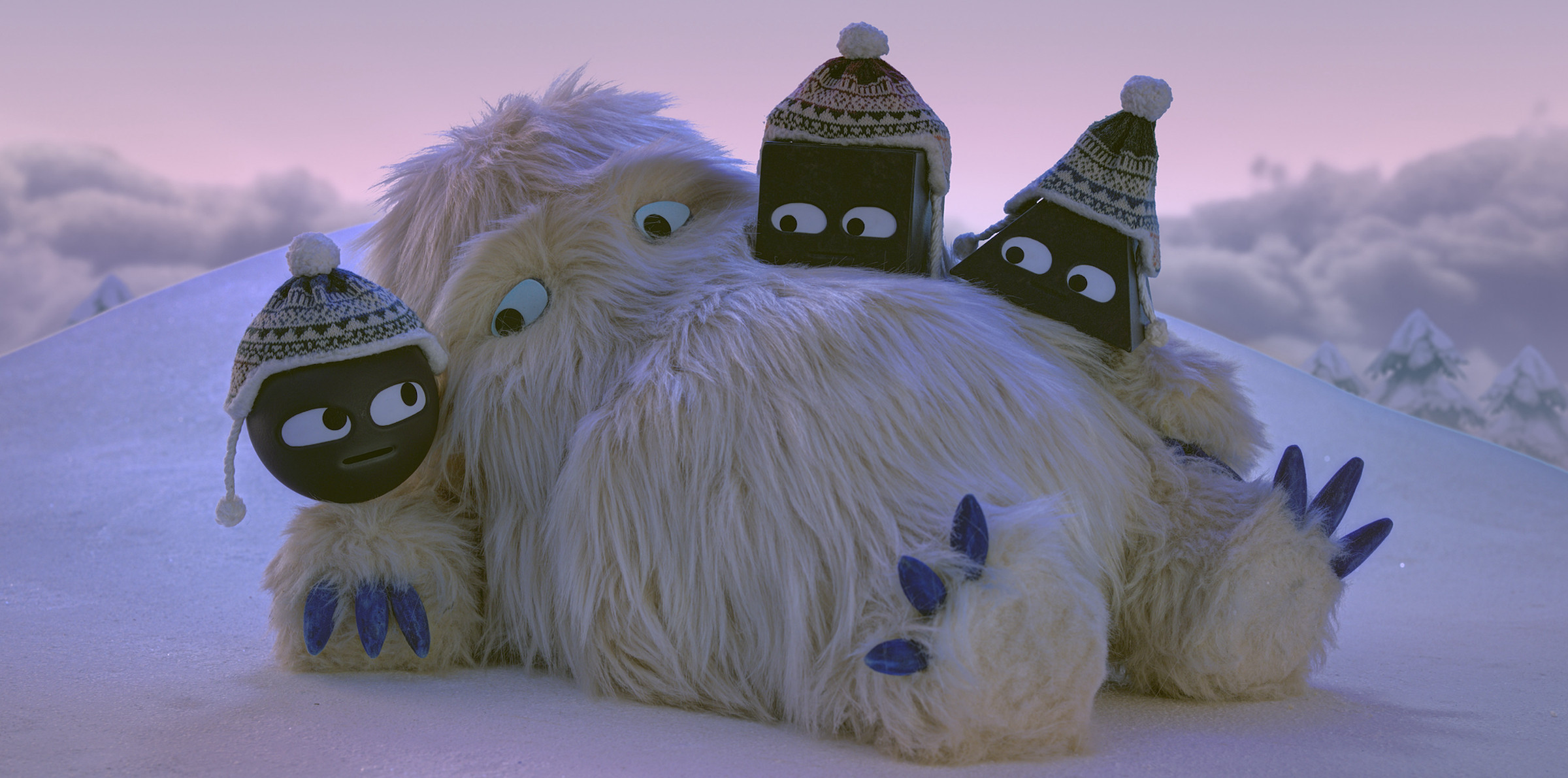 A picture from Shape Island, showing three black shapes with eyes and knit caps on sitting on a yeti, which is laying on the snowy ground. He is very shaggy.