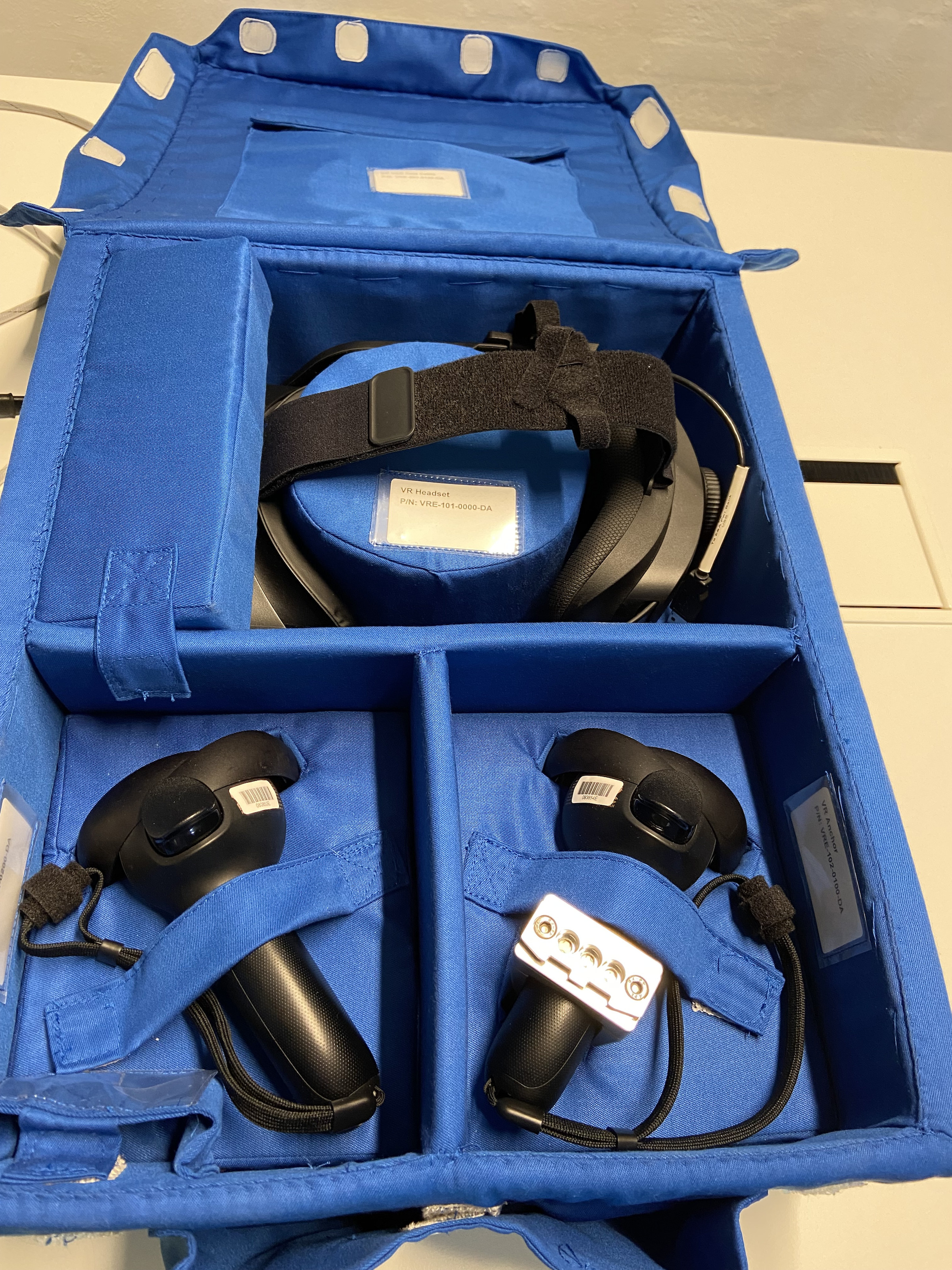 The Vive Focus 3 and its controllers packed in a blue bento-style box, with each component strapped down.