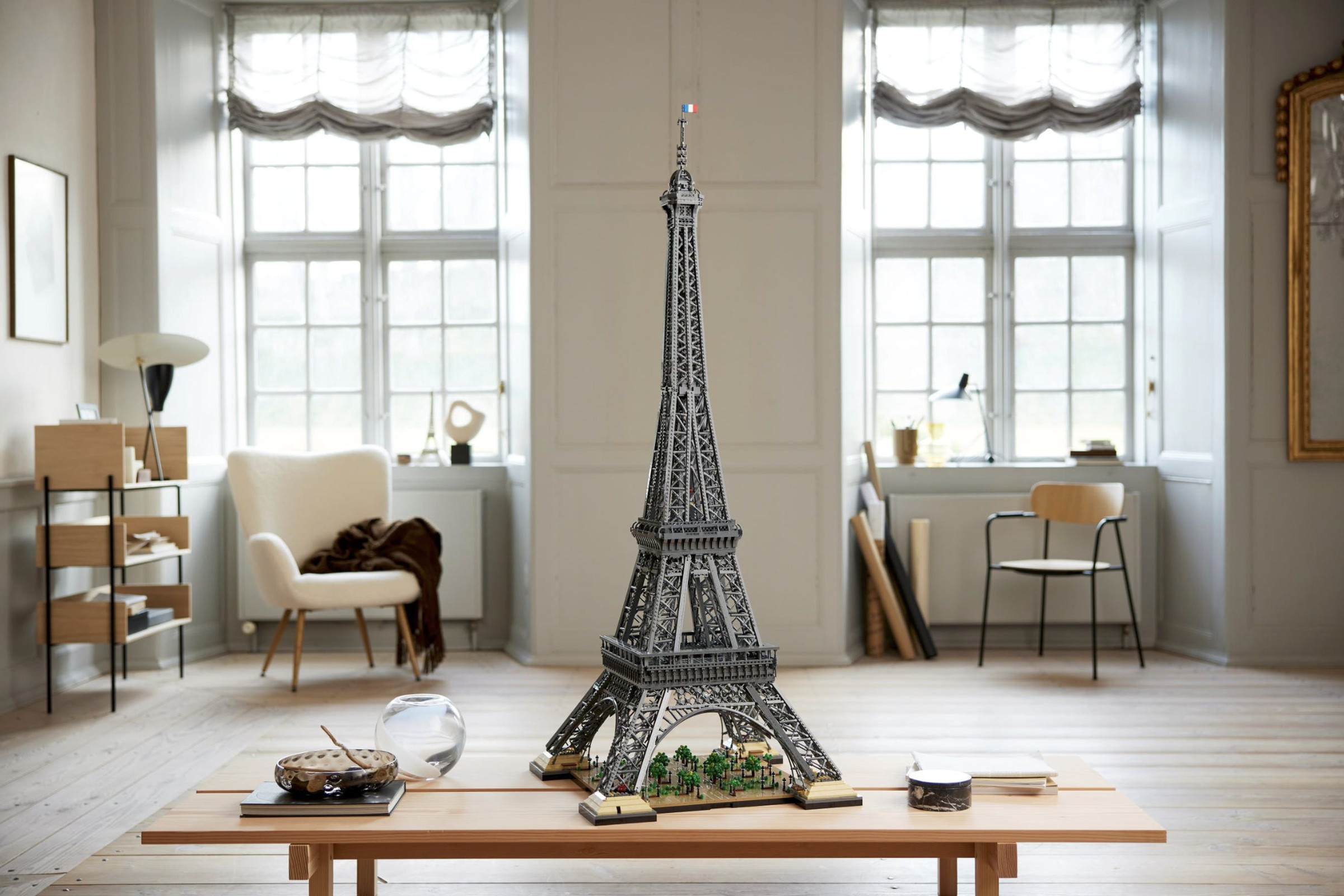 A five-foot tall Lego version of the Eiffel Tower, sitting on a table in a bright and airy living room.