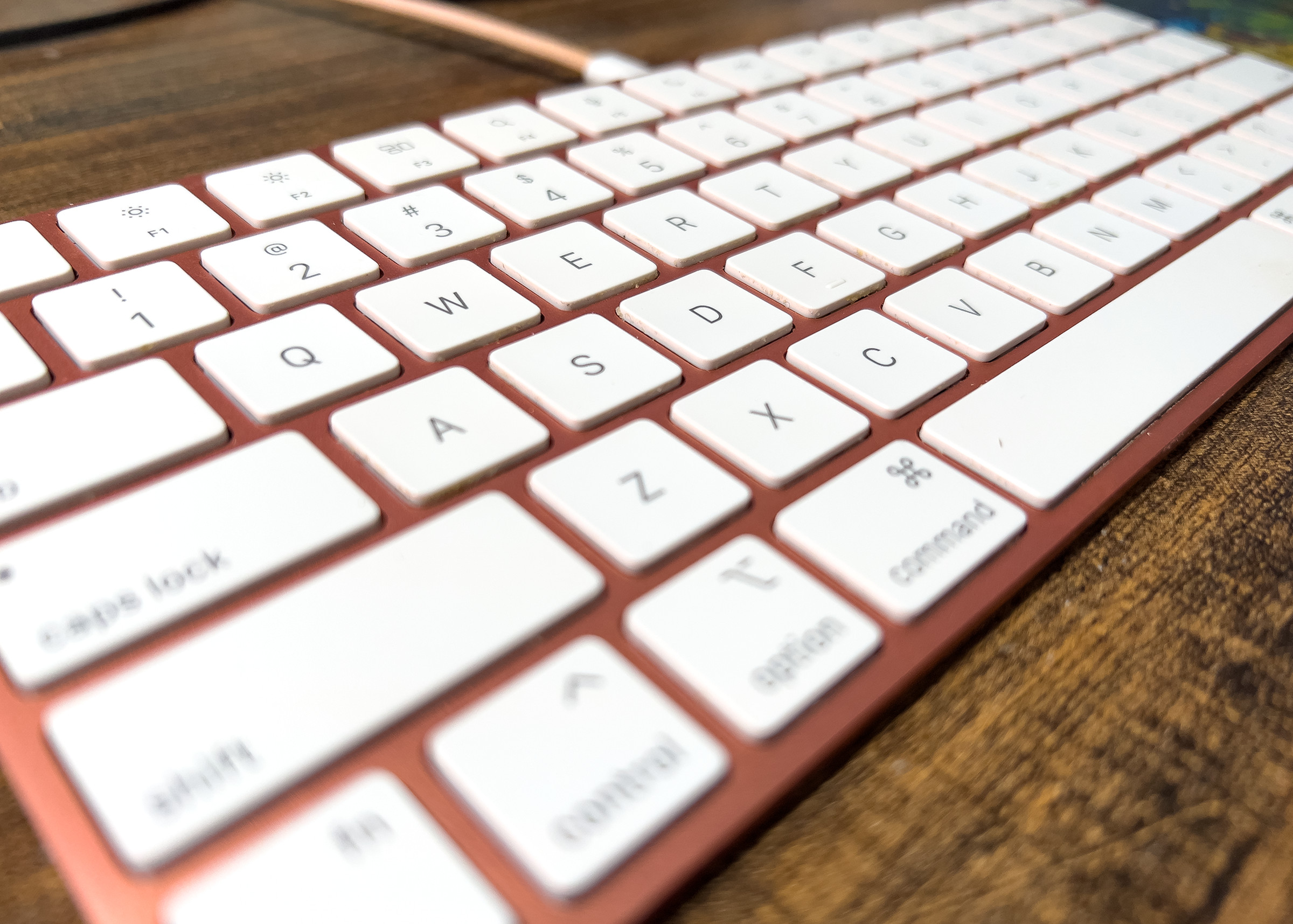 A close-up of the orange Magic Keyboard with Touch ID