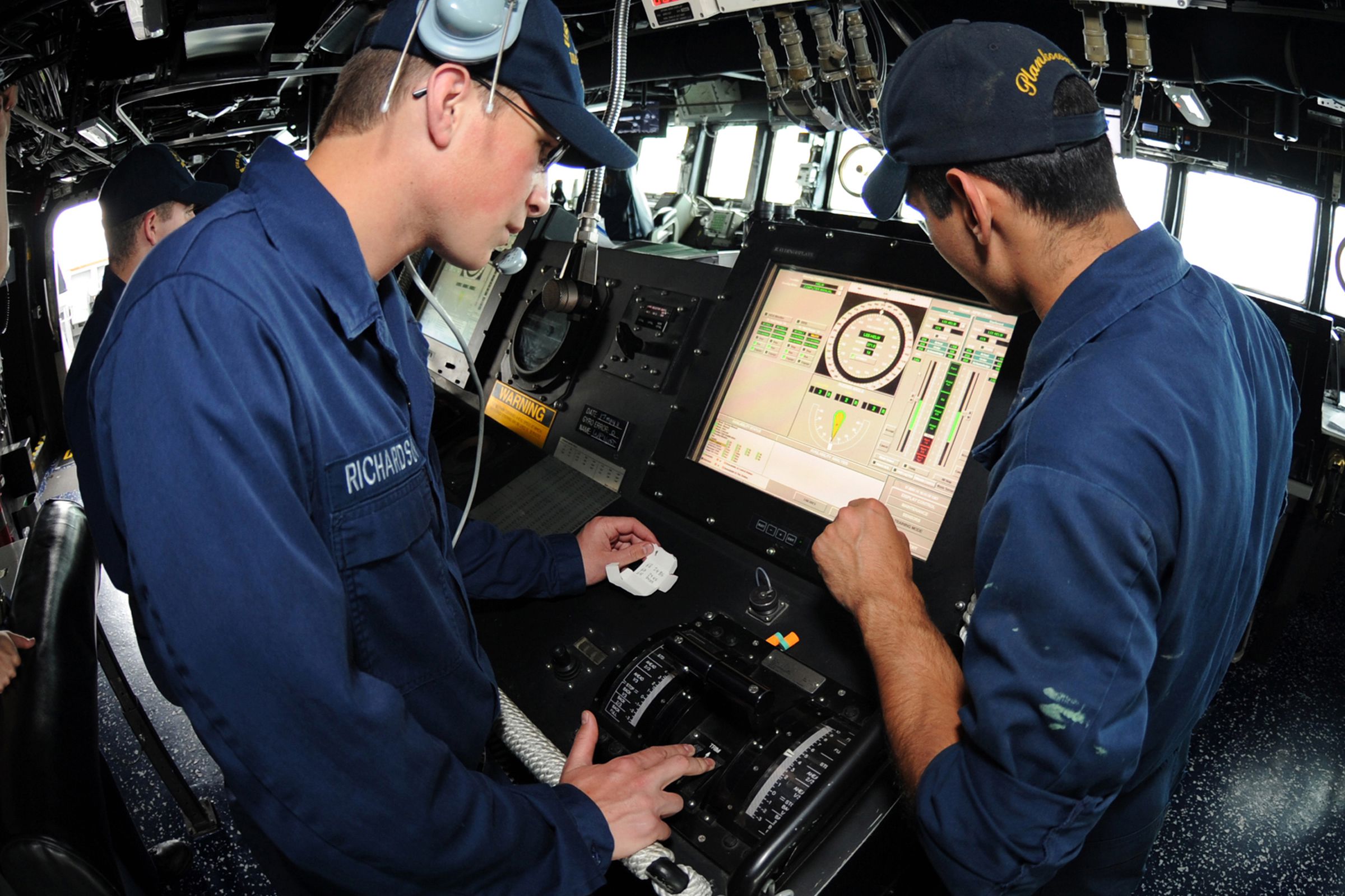 Gas Turbine System Technician (Electrical) Fireman Matt R. Richardson, left, receives training at the helm aboard the guided-missile destroyer USS Truxtun (DDG 103). 