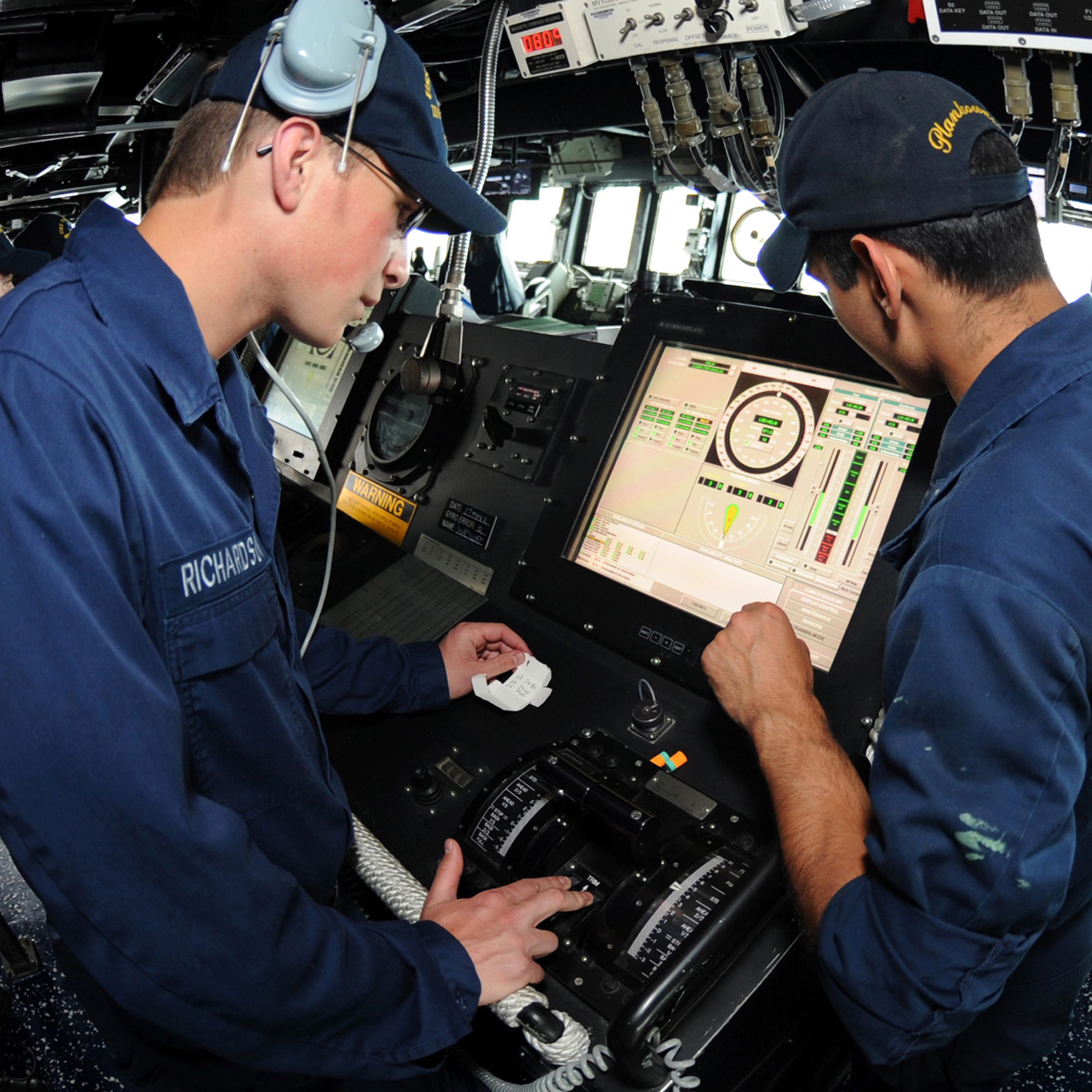 Gas Turbine System Technician (Electrical) Fireman Matt R. Richardson, left, receives training at the helm aboard the guided-missile destroyer USS Truxtun (DDG 103). 