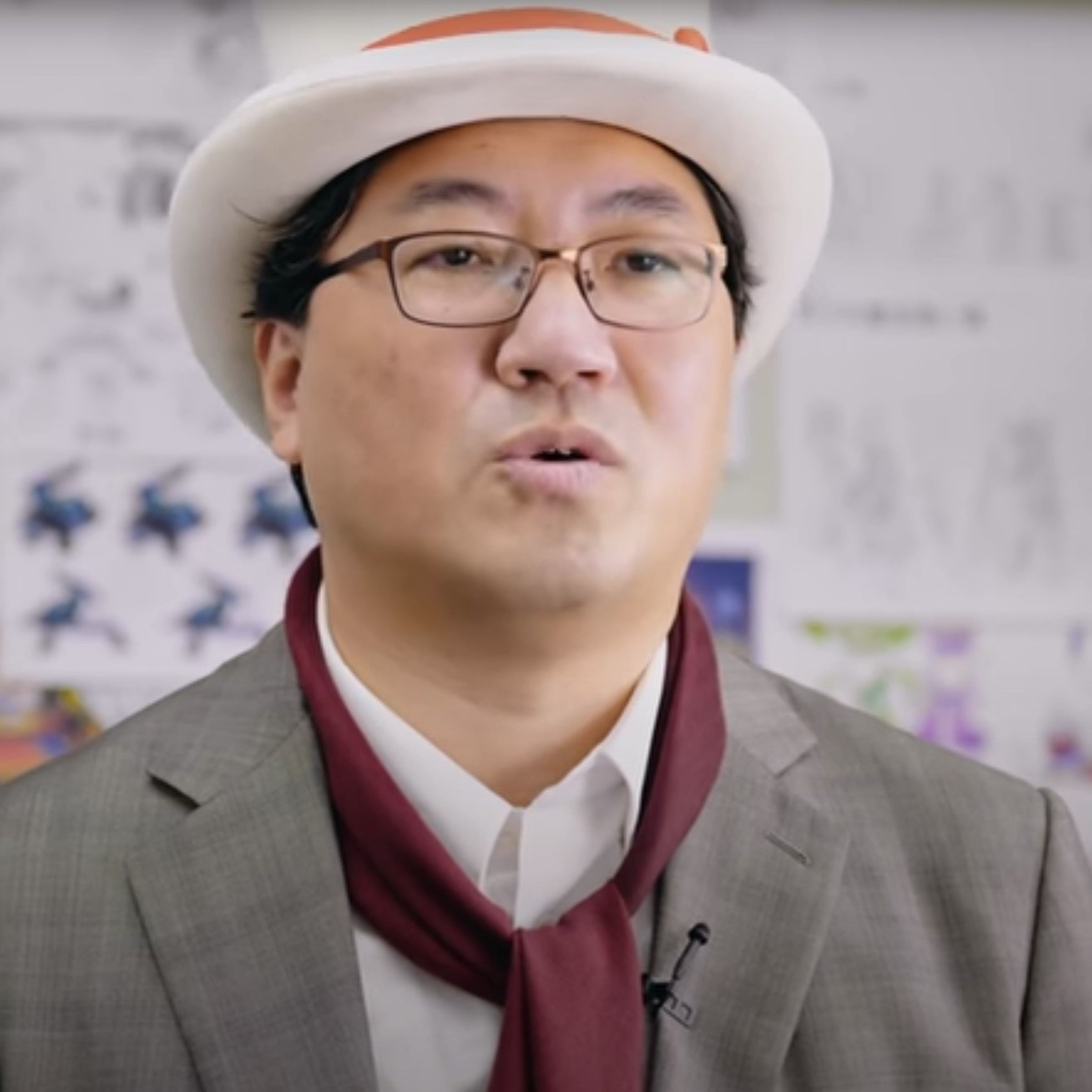 Yuji Naka in a white tophat and grey suit