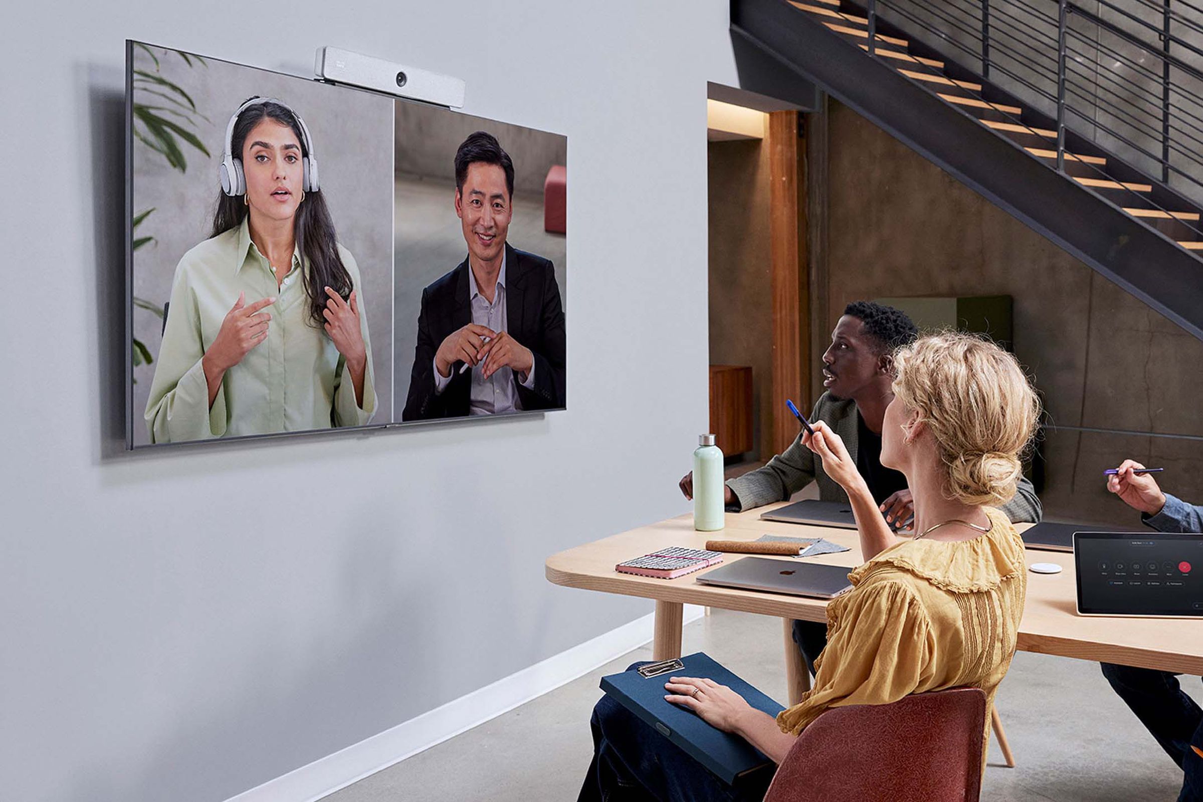 Employees hold a conference call using Cisco Room Bar.