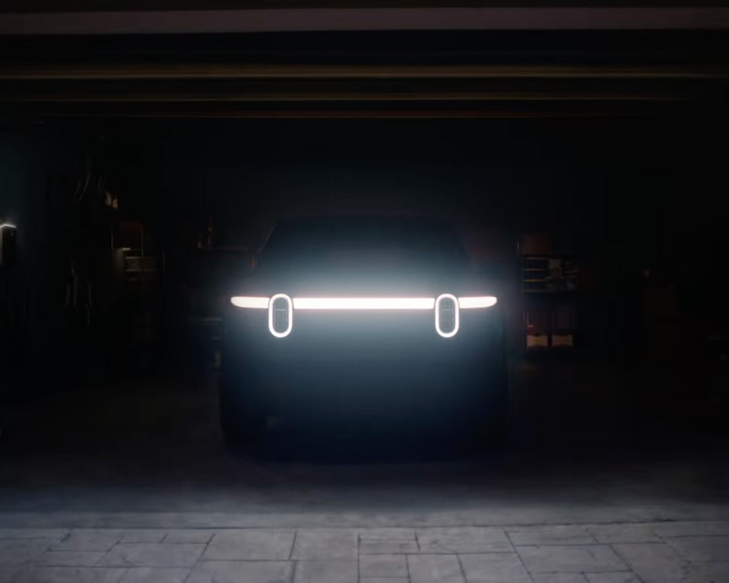 An SUV in a dark garage with headlights illuminated.