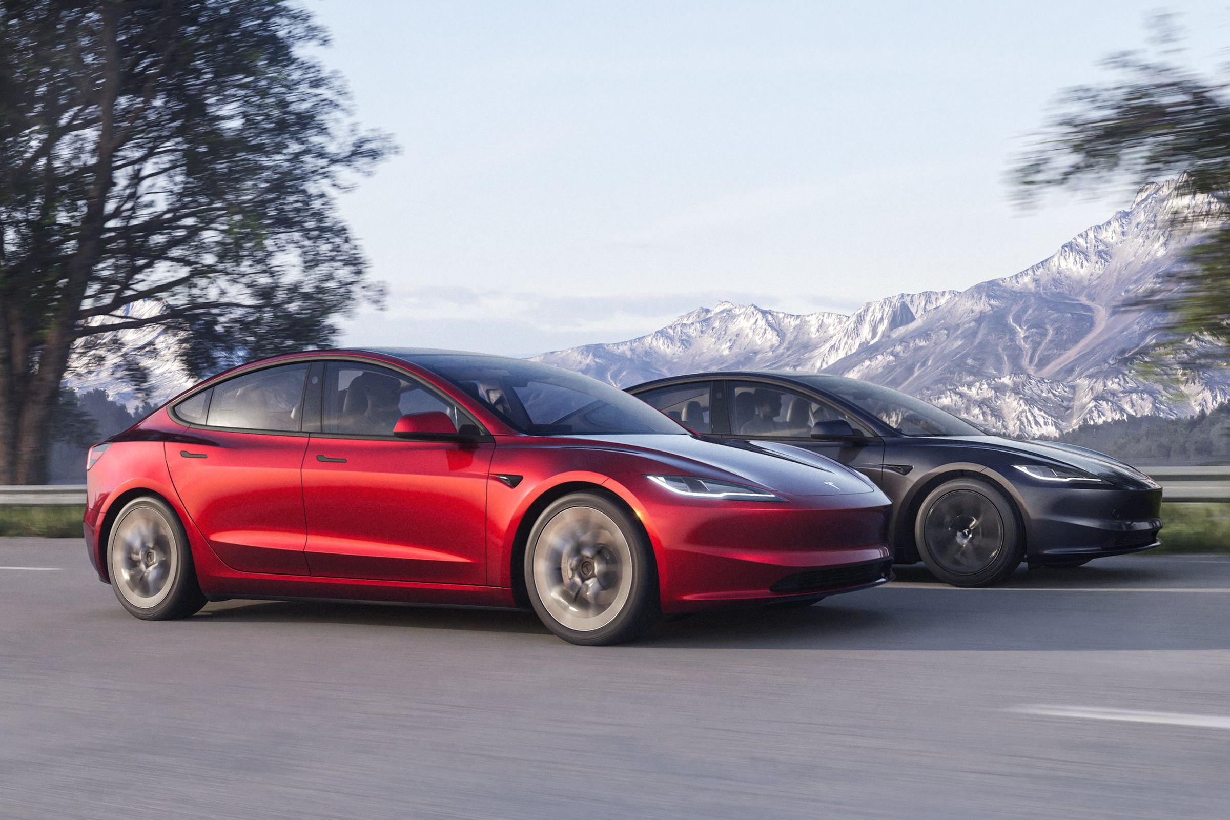 Two Tesla Model 3s shown driving on a mountain road, one red and one gray.