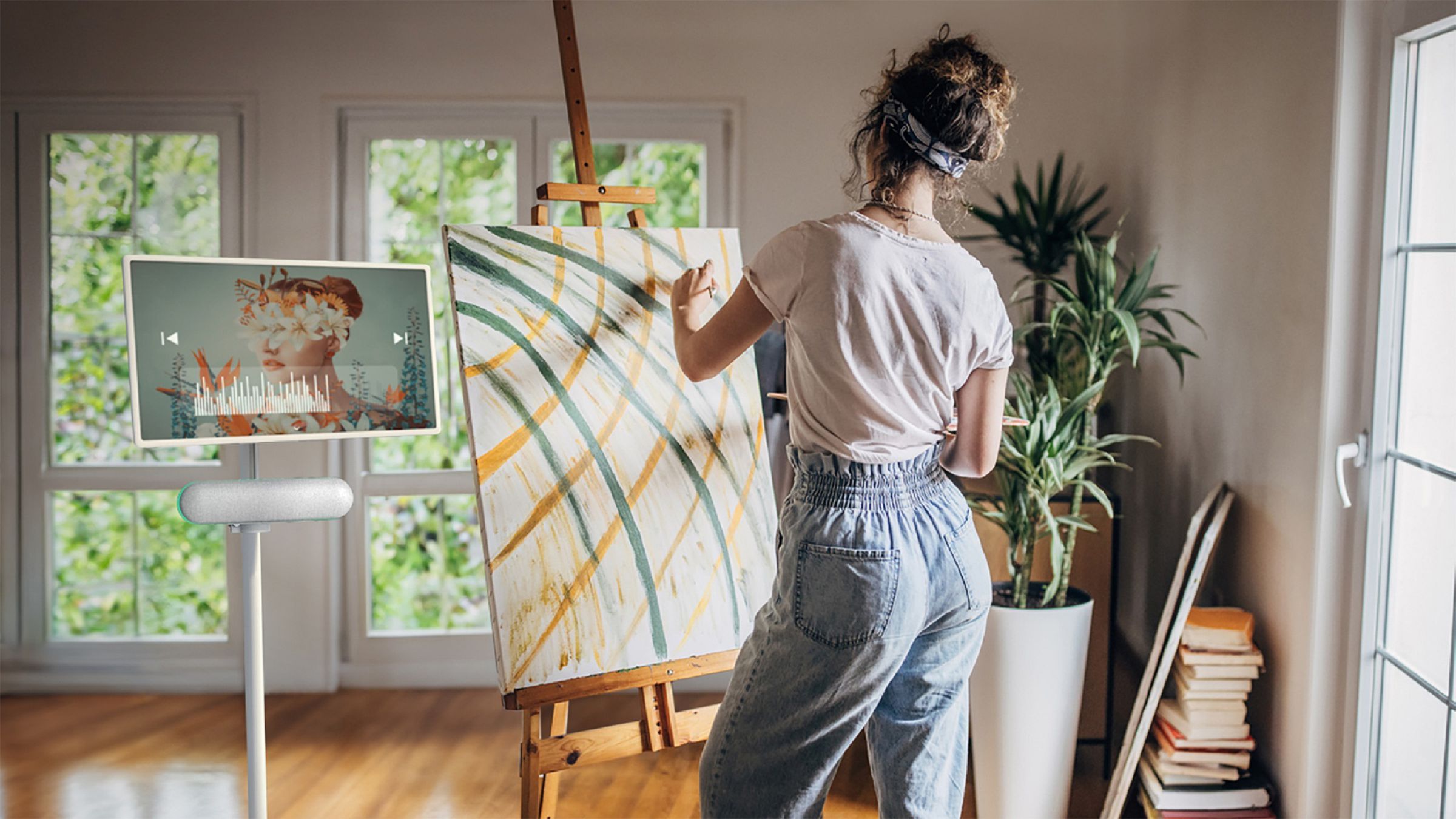 The LG StanbyME Speaker XT7S attached to the StanbyME TV, with someone painting on a canvas.