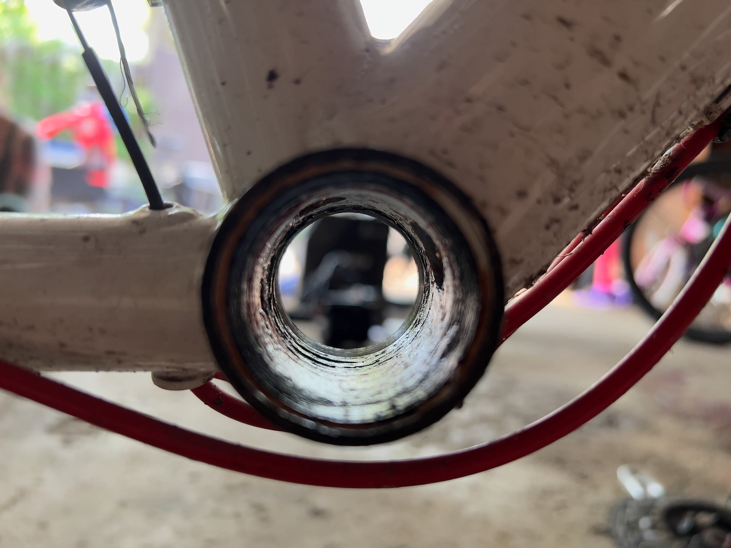 A picture taken through the empty bottom bracket shell after the bottom bracket has been removed but the grease hasn’t been cleaned out yet.
