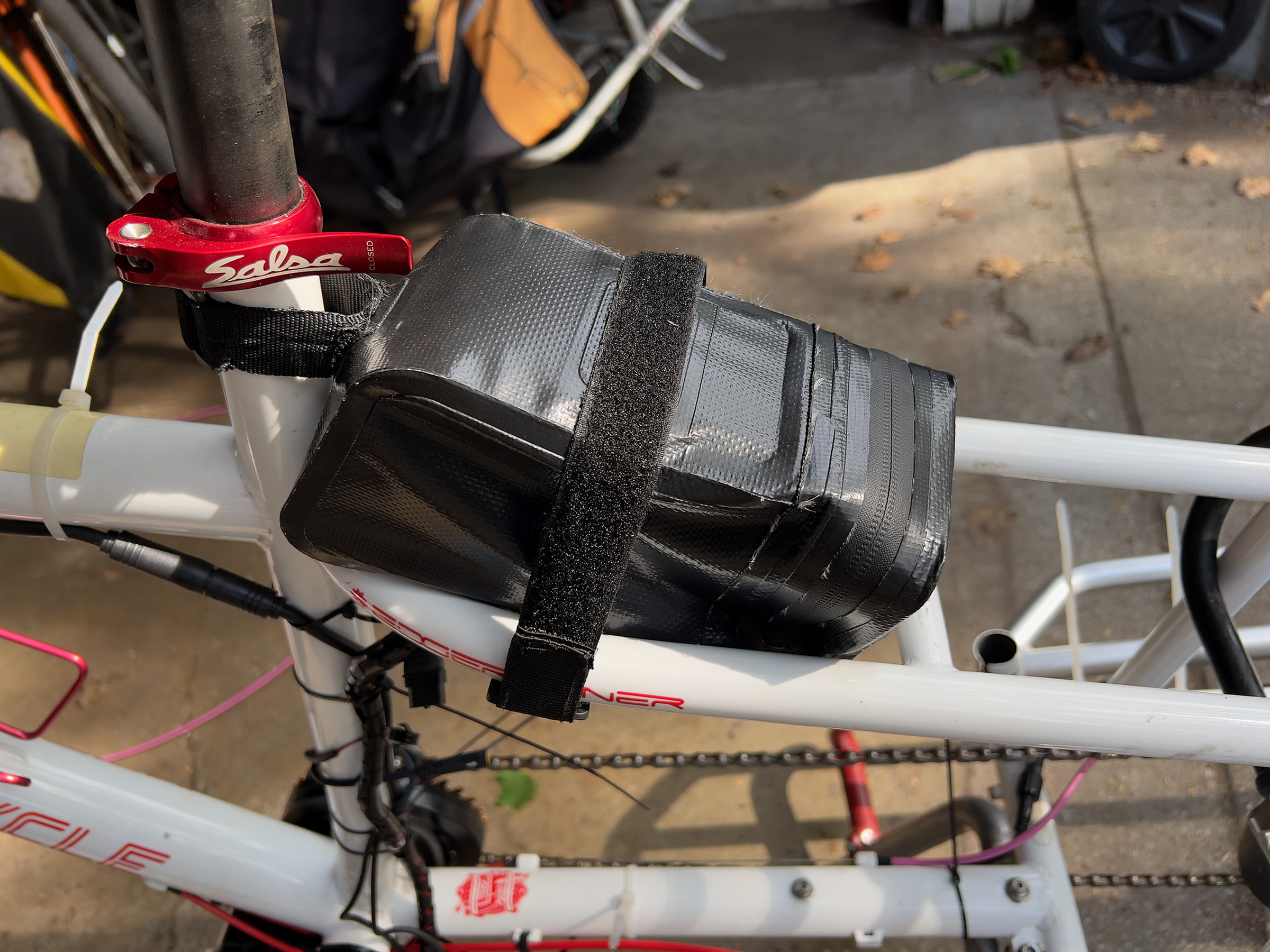 A picture of the battery bag strapped to the frame, with its velcro straps struggling to hold on.