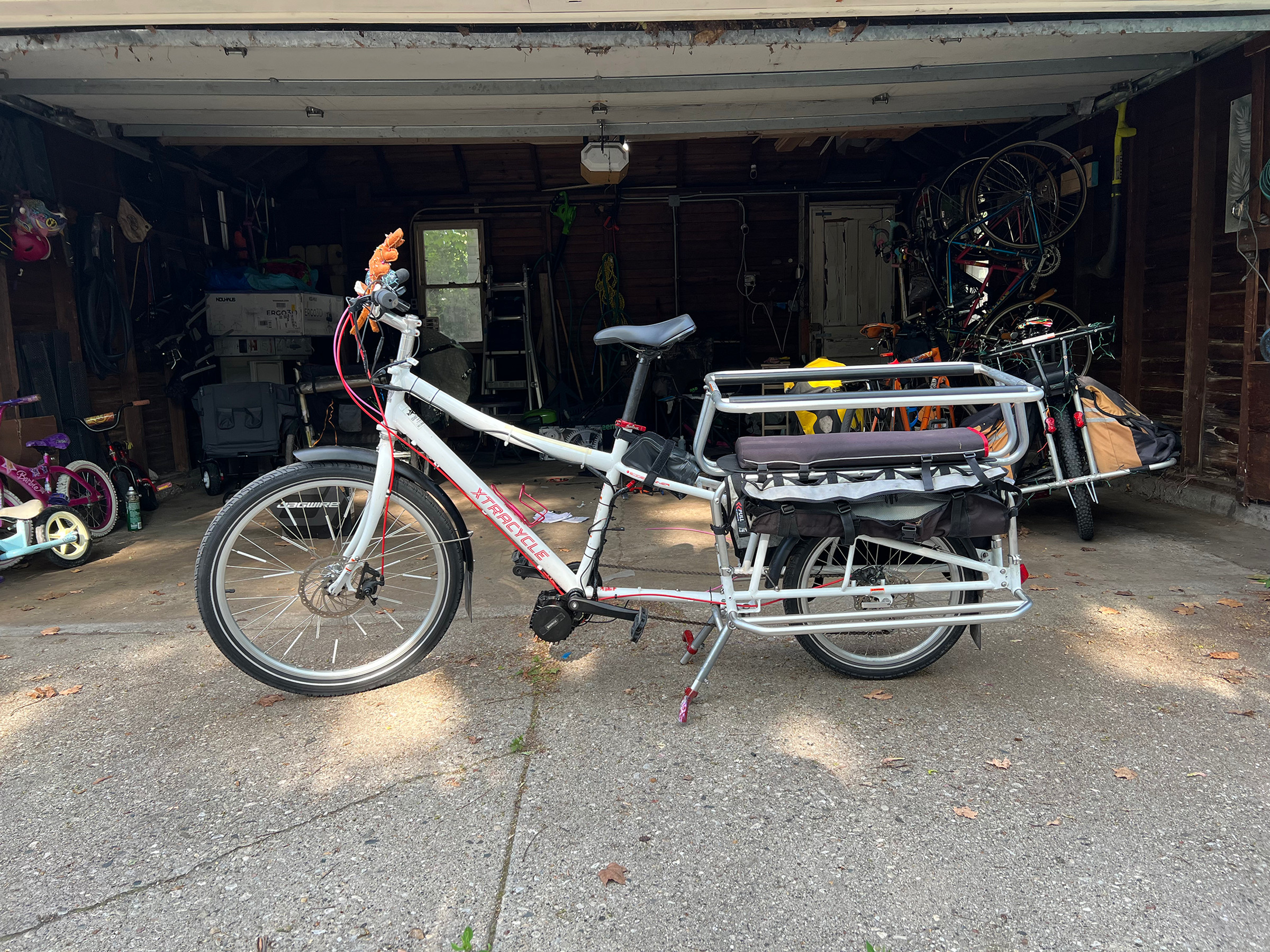 A picture of the cargo bike in front of the garage again, this time with the motor installed.