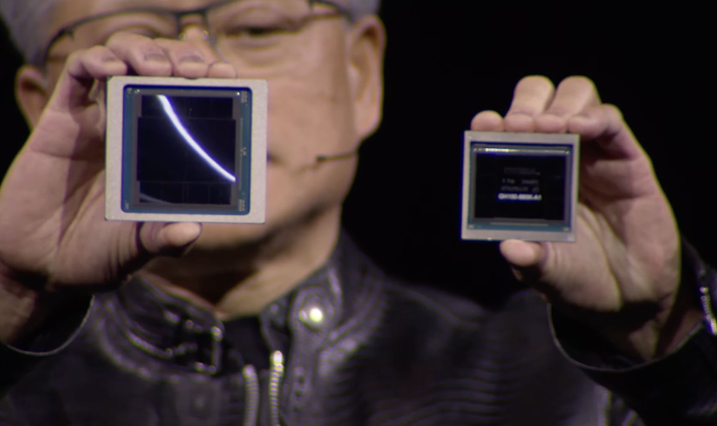 Nvidia CEO Jensen Huang holds up his new GPU on the left, next to an H100 on the right, from the GTC livestream.