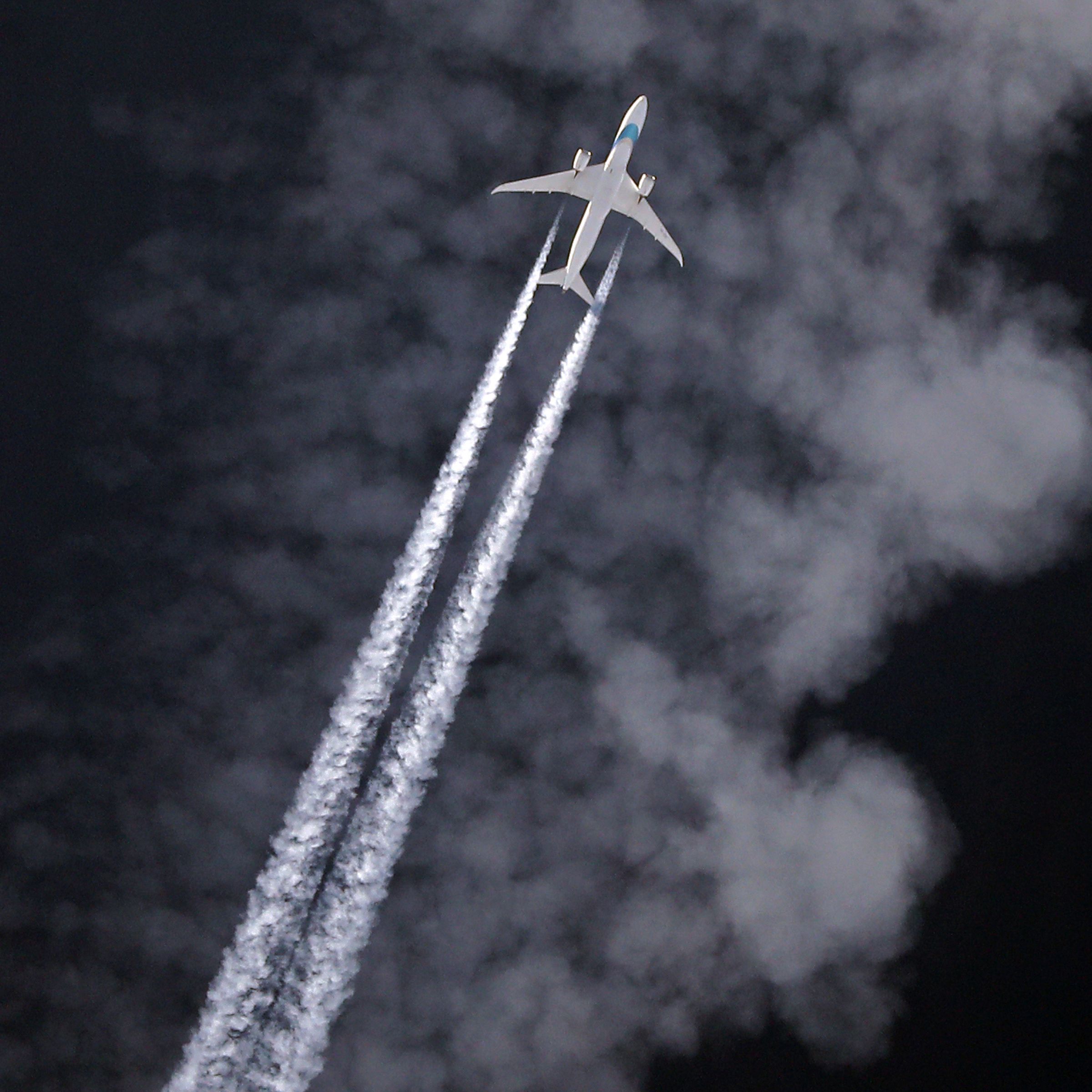 A plane flying with contrails behind it