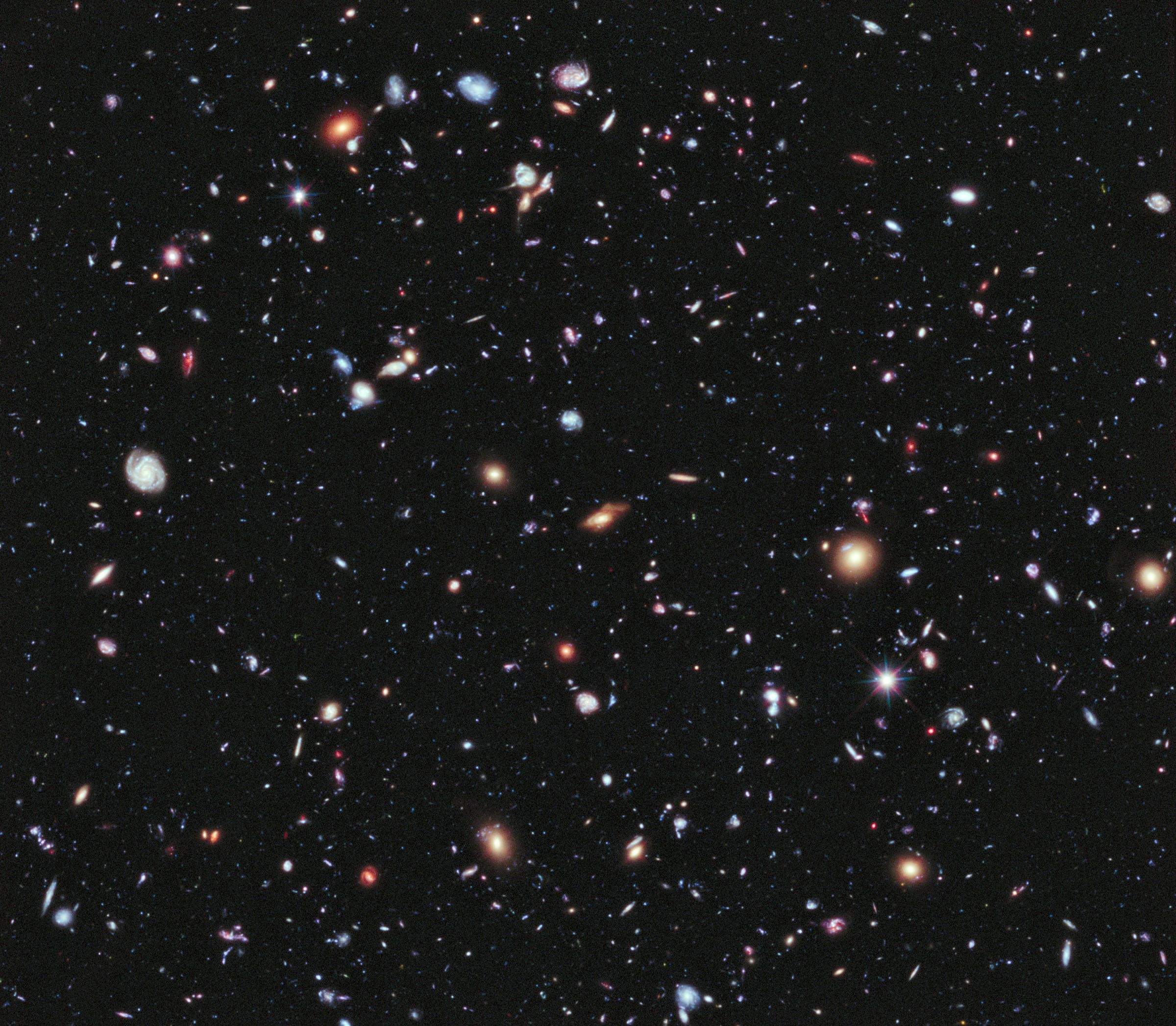 Multicolored galaxies scattered across a deep black background