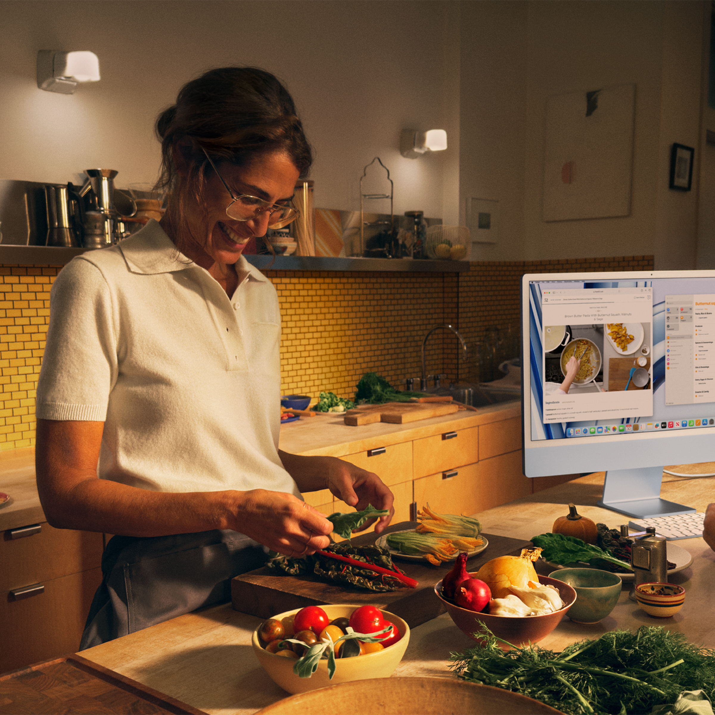 Person cooking in kitchen with blue iMac in background