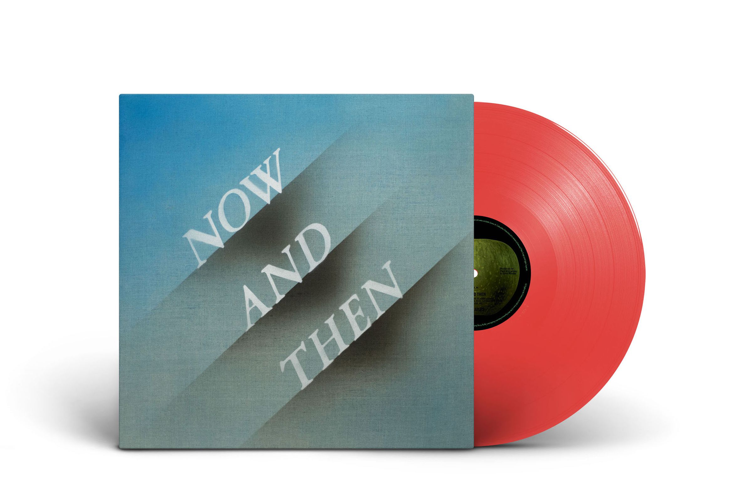 An album cover that reads “Now and Then” along with a red vinyl record with a black center. Both are standing up against a white backdrop.