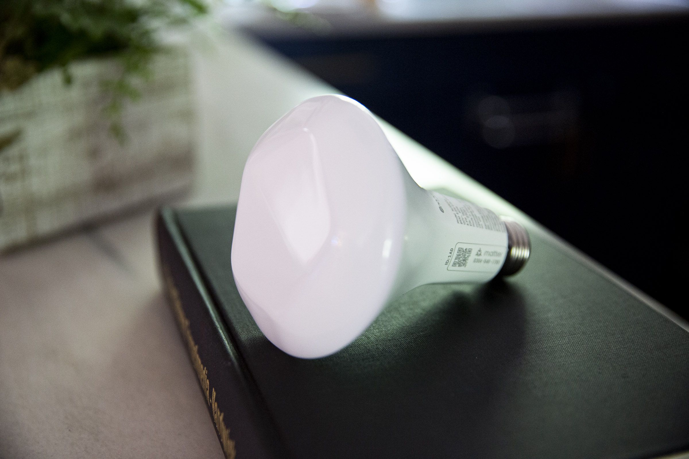 A smart bulb on a book on a kitchen counter.