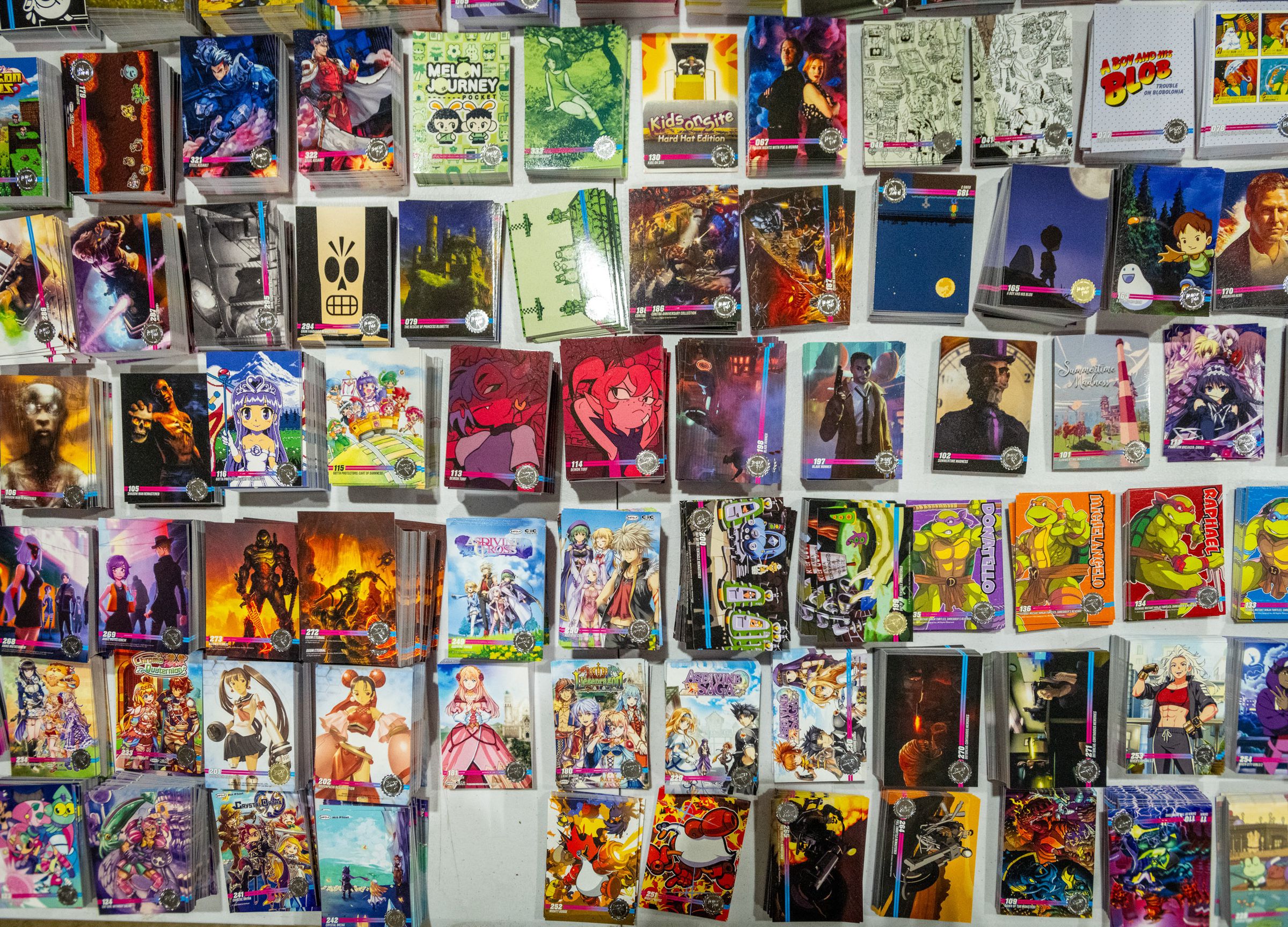 Dozens of different colorful trading cards stacked neatly on a surface for browsing.