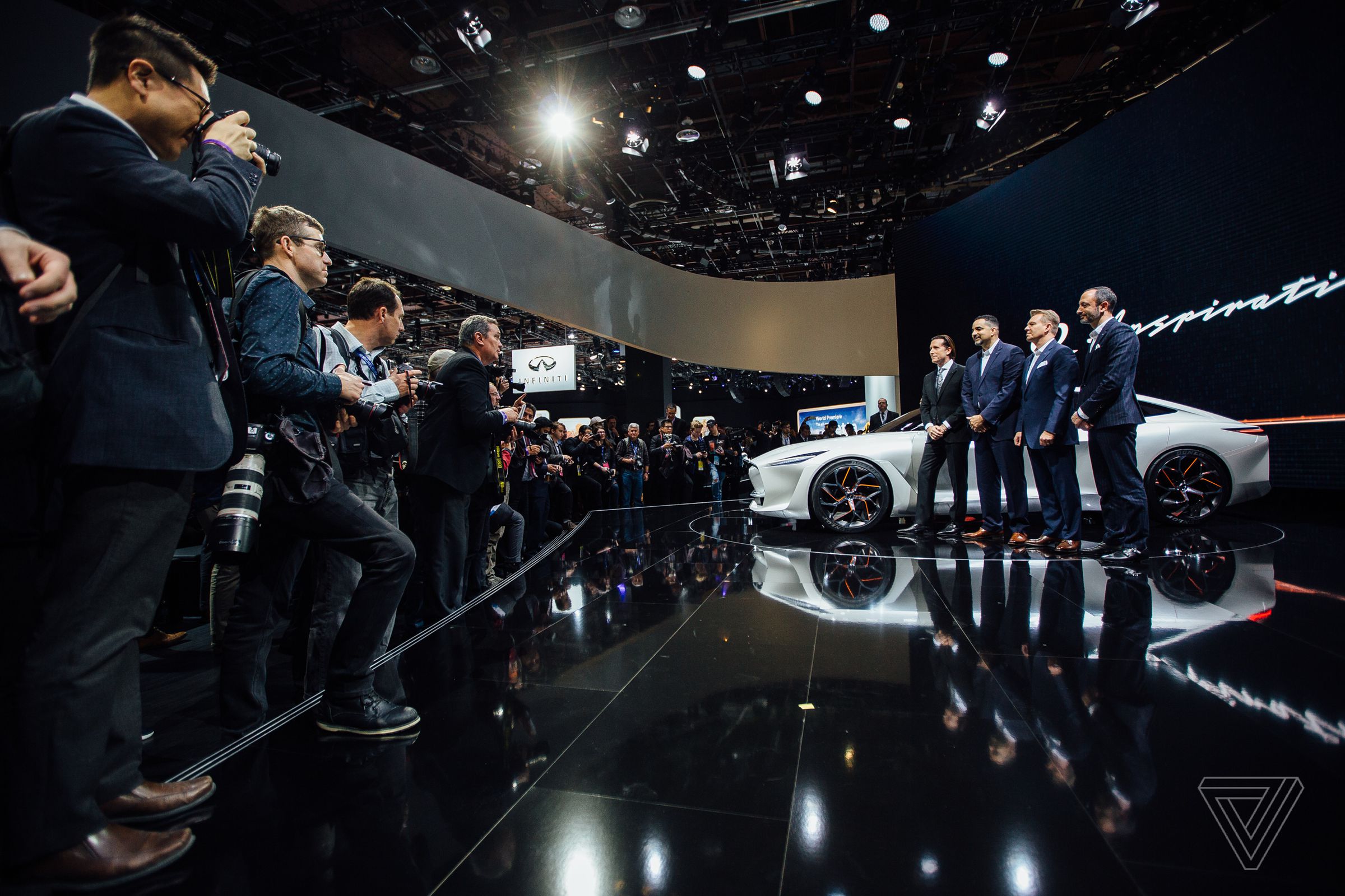 Infiniti executives pose for photos after revealing the Q Inspiration concept car.