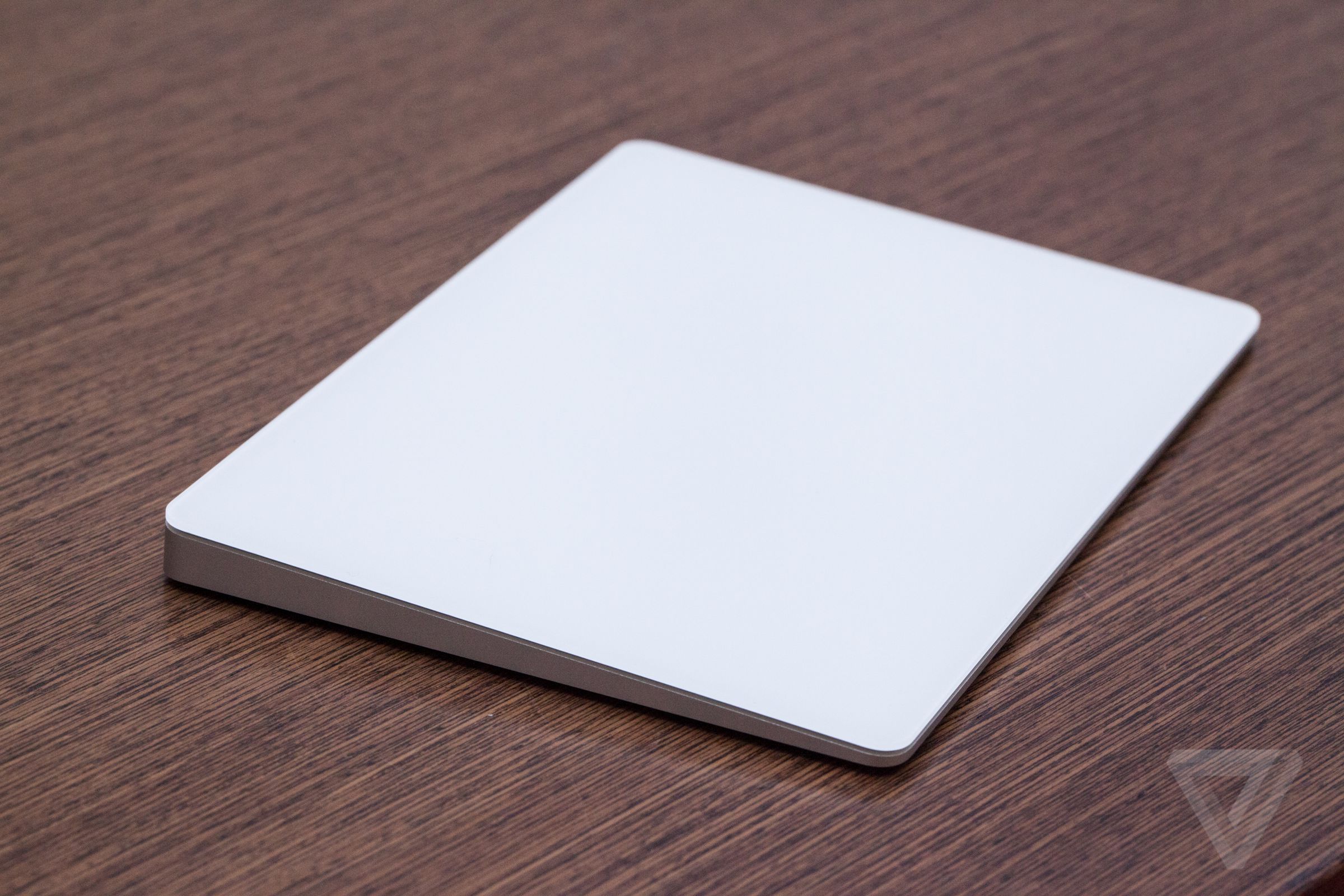 A photo of the Apple Magic Trackpad 2 on a wooden surface