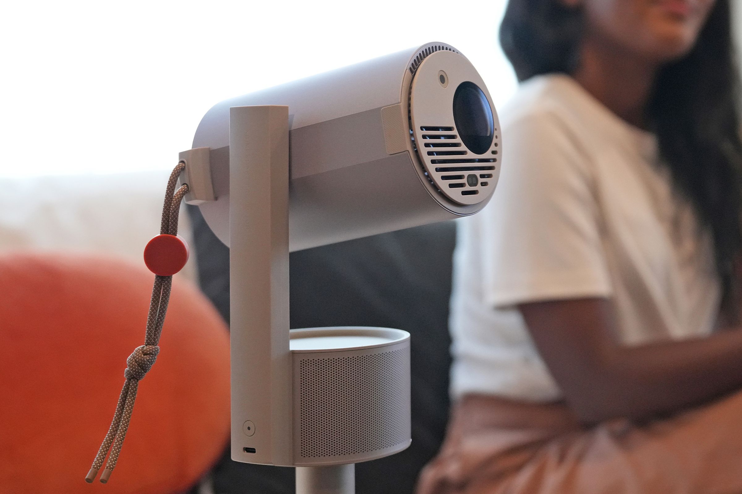 The MoGo 3 Pro being used to project on a wall with a person sitting behind it.