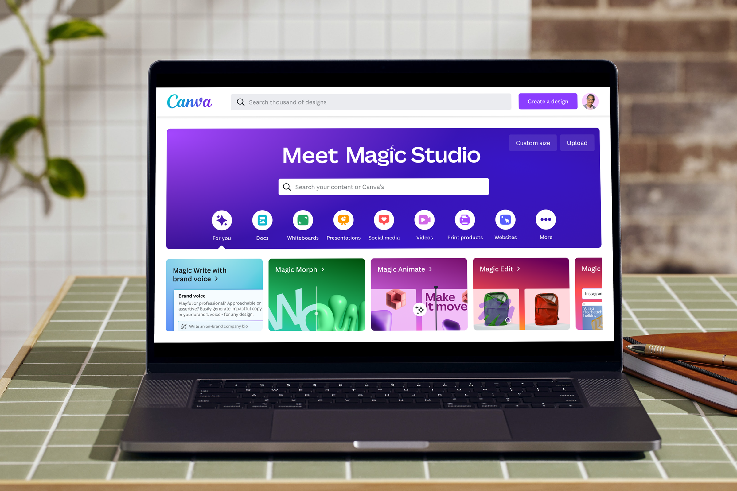 A laptop displaying the Canva website’s new Magic Studio deisgn tools.