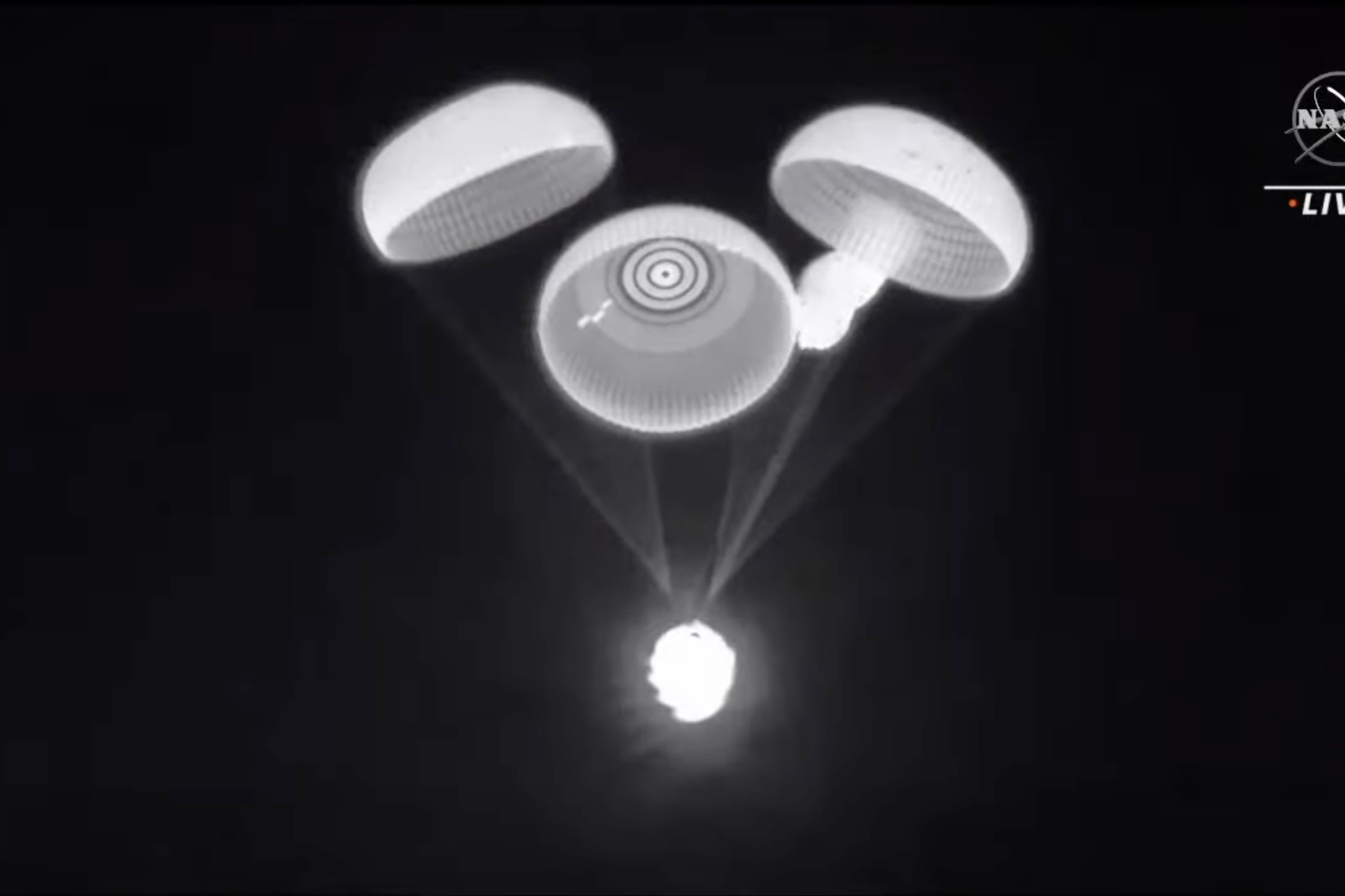 A screengrab of the livestream during the Crew-2 landing, showing the one lagging parachute
