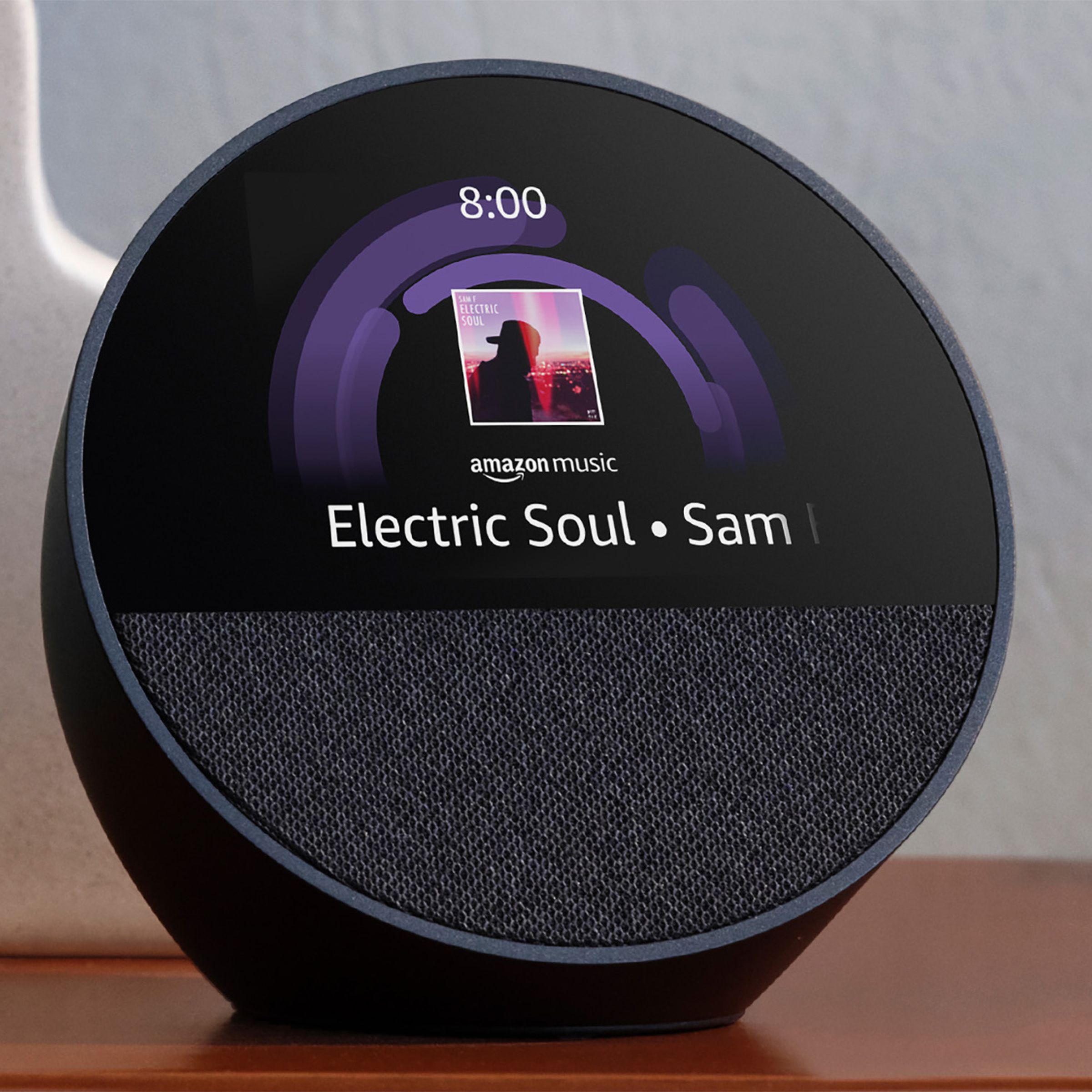 Amazon Echo Spot smat speaker sitting on a table with cover art and title of a song “Electric Soul” playing via Amazon Music.