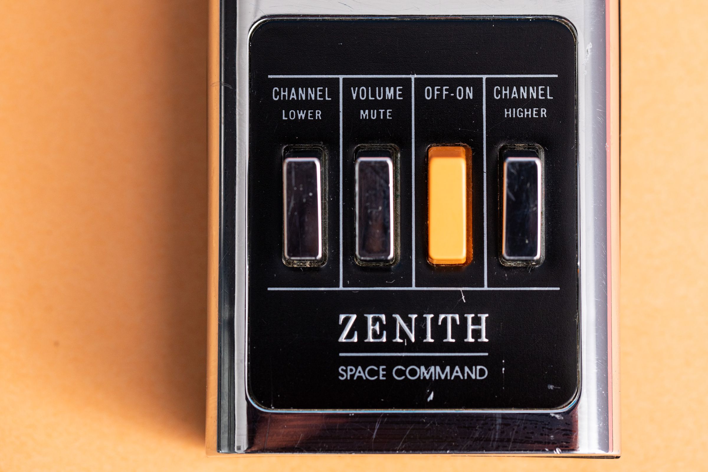 Front face of Zenith Space Command with Zenith logo and four buttons. Channel Lower, Volume Mute, OFF-ON, Channel Higher. 