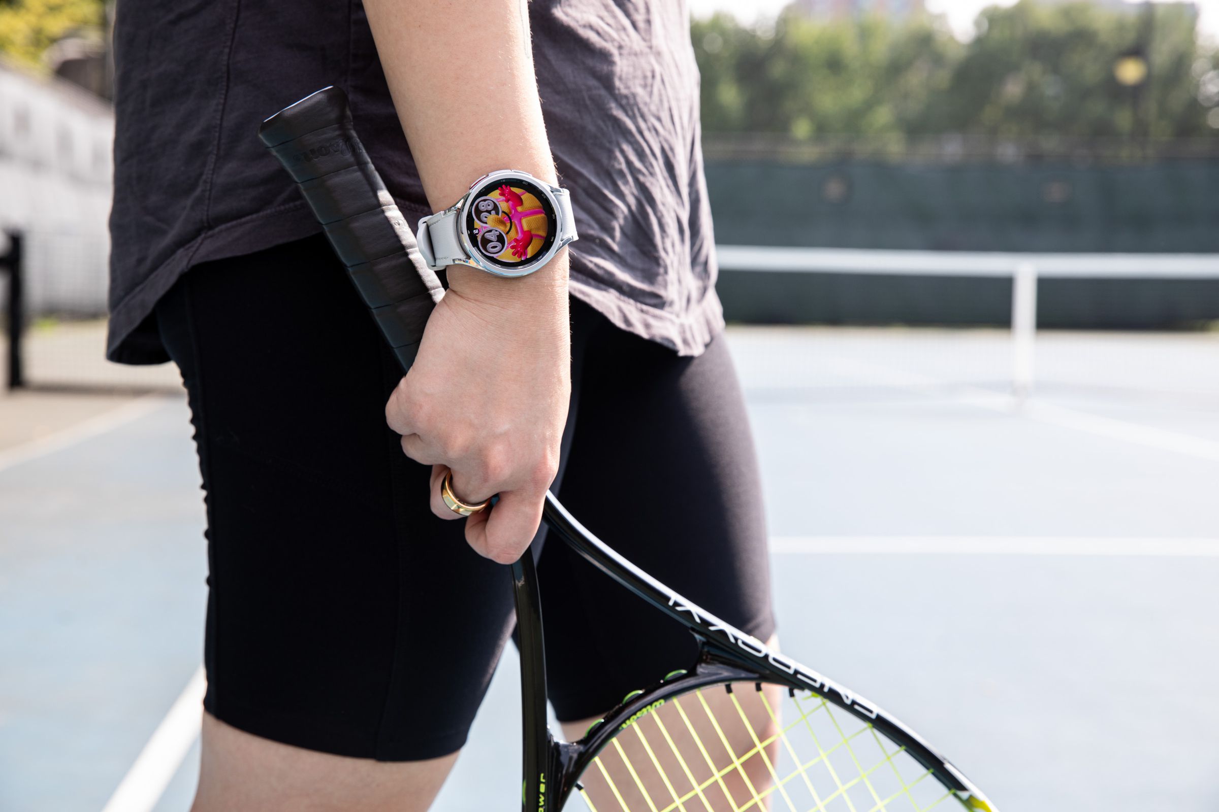 Person wearing Galaxy Watch 6 while holding tennis racket