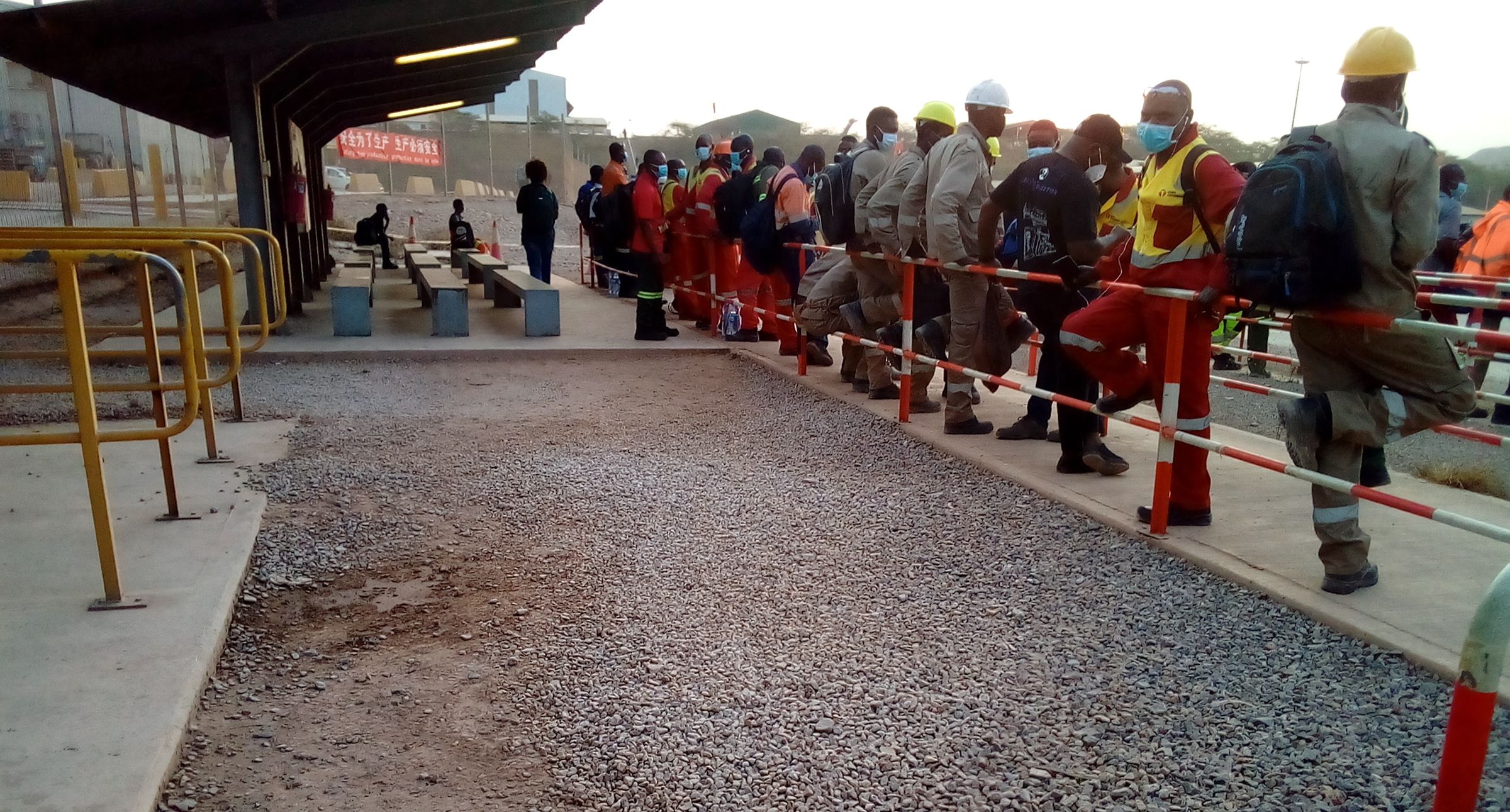 Industrial cobalt mine workers waiting for a company bus.