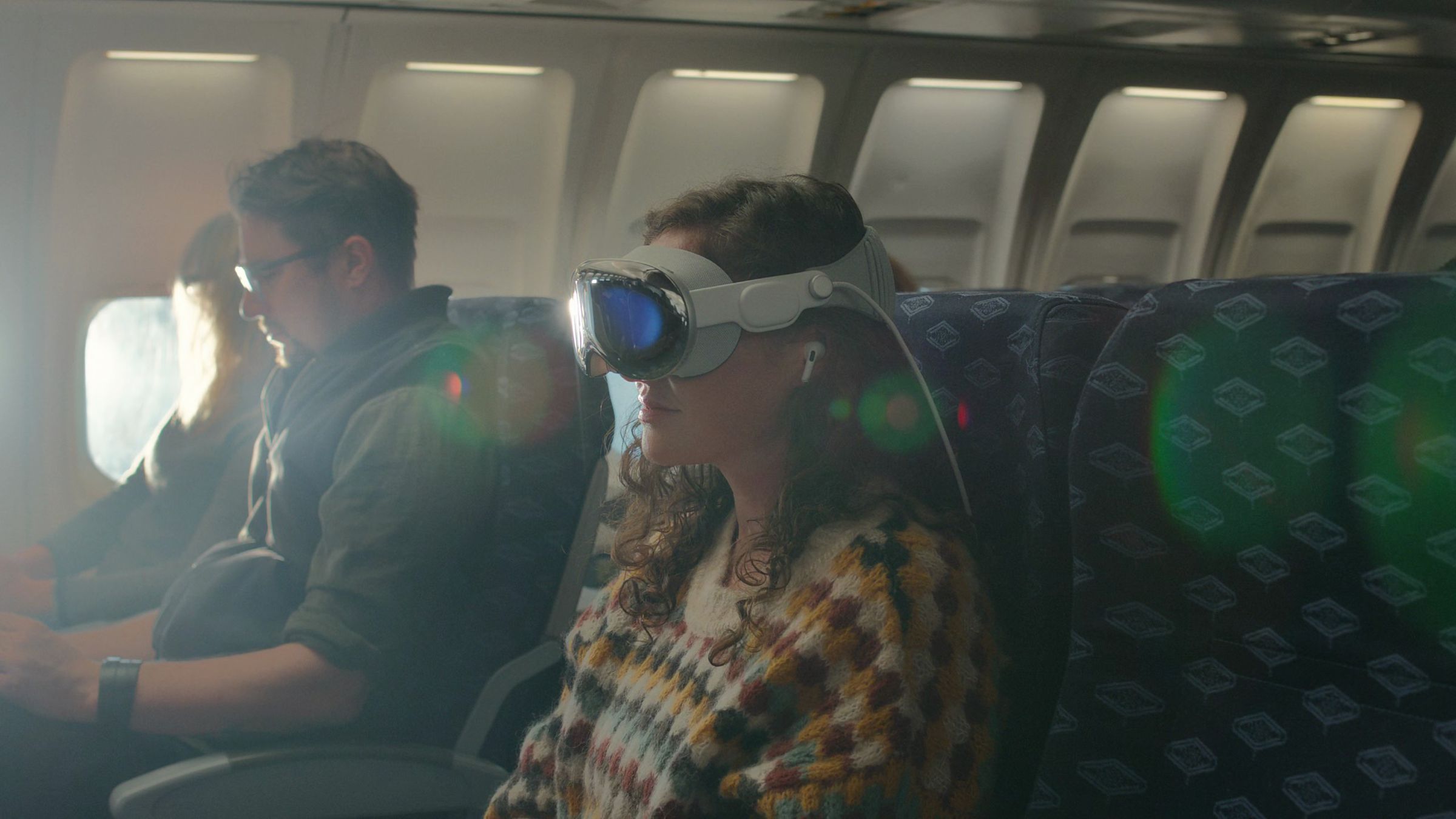 A person wearing a Vision Pro headset while on a plane
