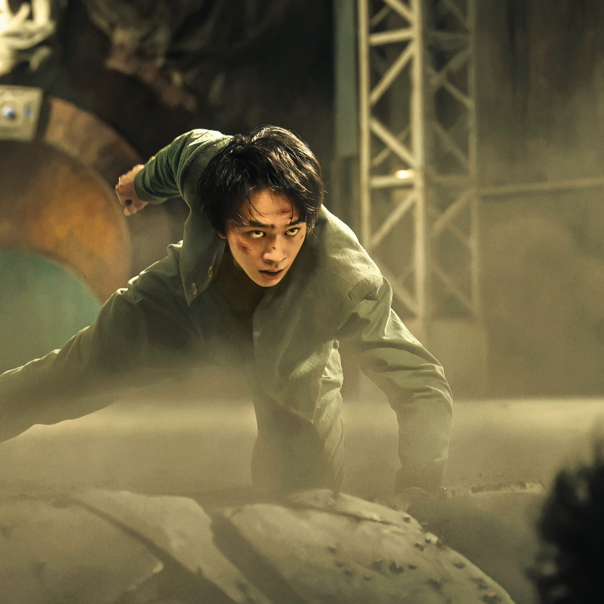 Production image from Netflix’s live-action Yu Yu Hakusho show featuring Takumi Kitamura as Yusuke Urameshi, a teenage boy in a green school uniform covered in blood as he kneels on the ground.