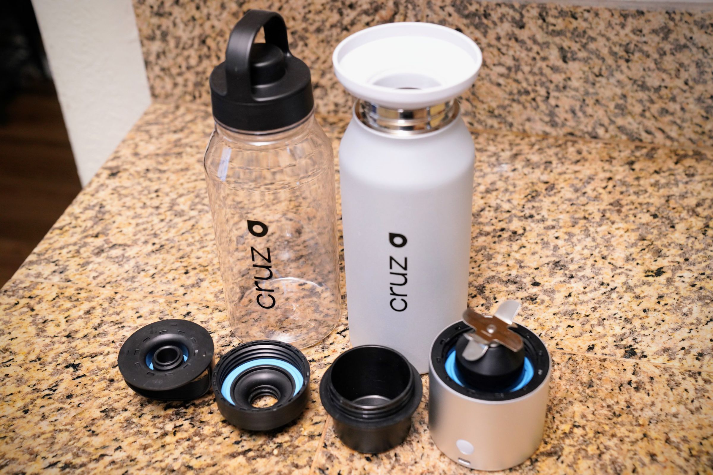 Everything that comes with the BlenderCap, for now (the clear bottle is a limited-time bonus). The tallest black plastic object is a blender cap for the BlenderCap itself. 