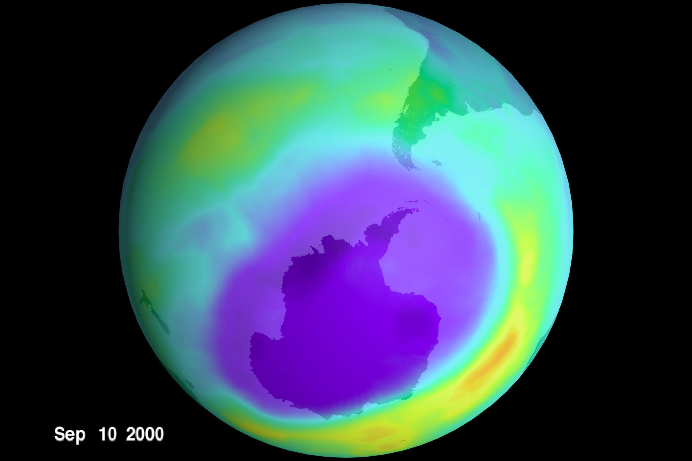 A rendering of a massive hole in the ozone layer over Antarctica. The hole is depicted purple, while a green layer covers the rest of the planet.