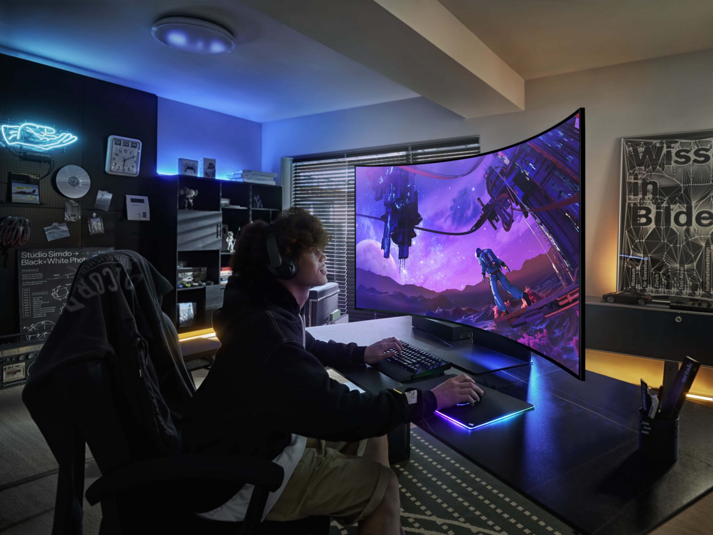 Image of someone gaming on the Odyssey Ark. Even in landscape mode, the top of the screen is significantly taller than they are.