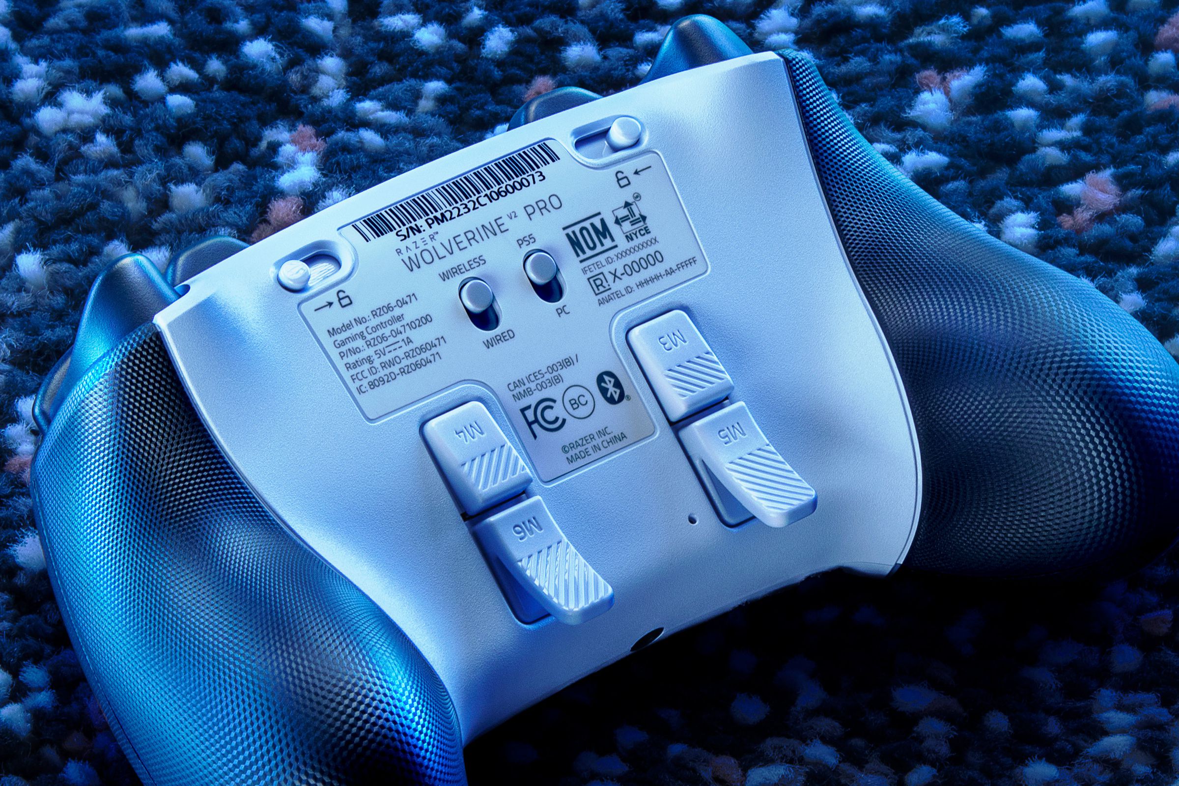 Esta imagem mostra a parte traseira do Wolverine V2 Pro, um controle da Razer para as plataformas PS5 e PC.  Mostra os botões programáveis ​​traseiros.