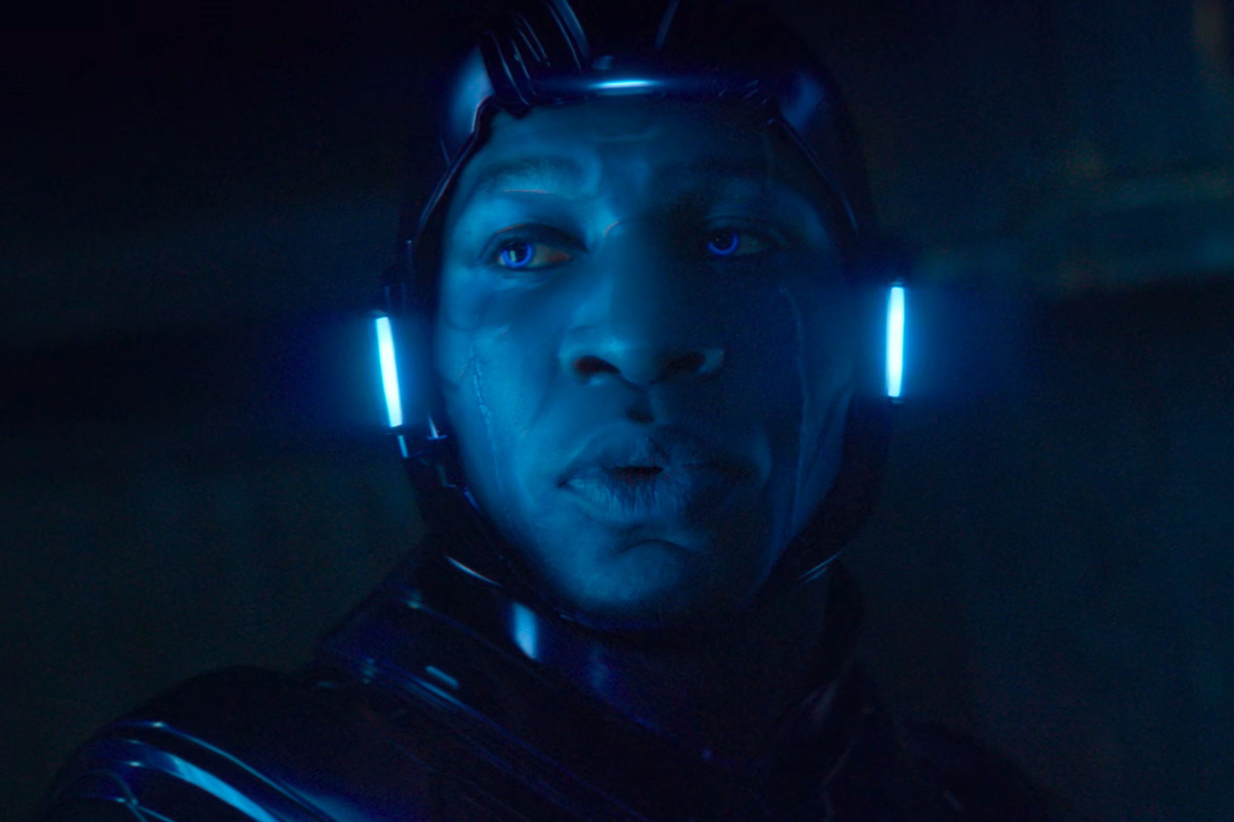 A tight shot of a man wearing a formfitting helmet that casts a translucent blue sheen over his face, which is visible from his hairline down to his chin.