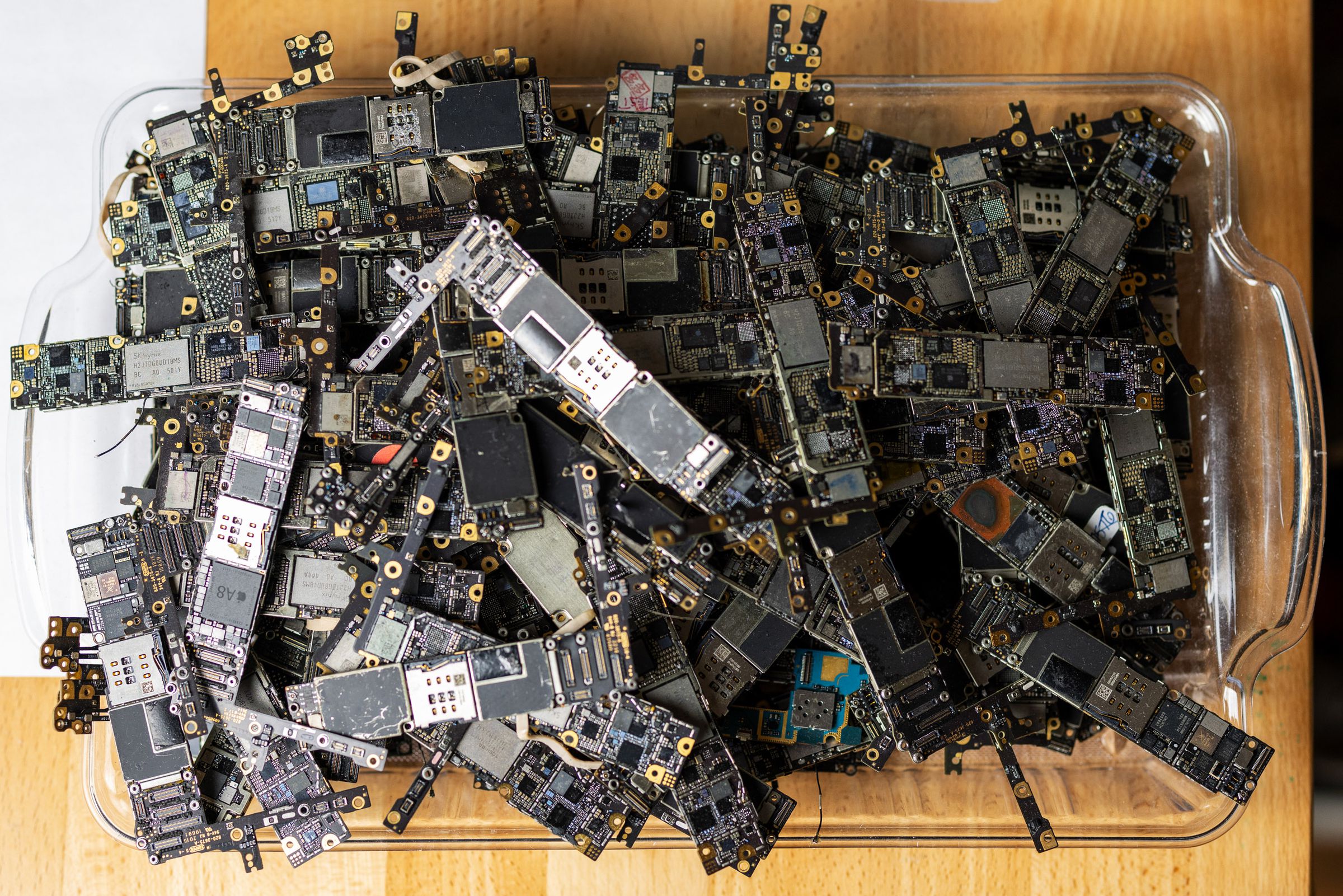 A pile of logic boards used for training sits in the iPad Rehab microsoldering shop.