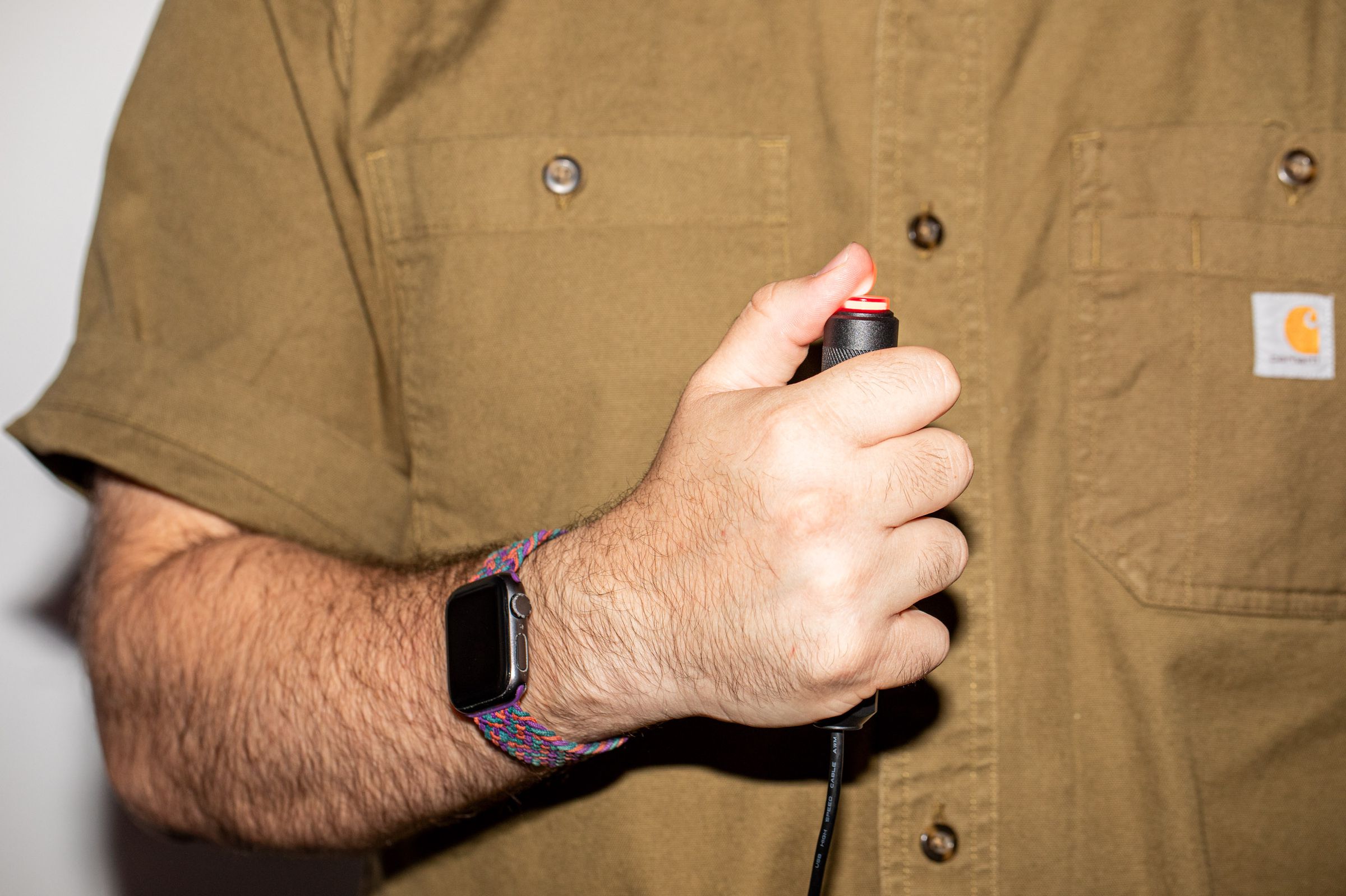 A hand holding the Delcom buzzer against the chest.